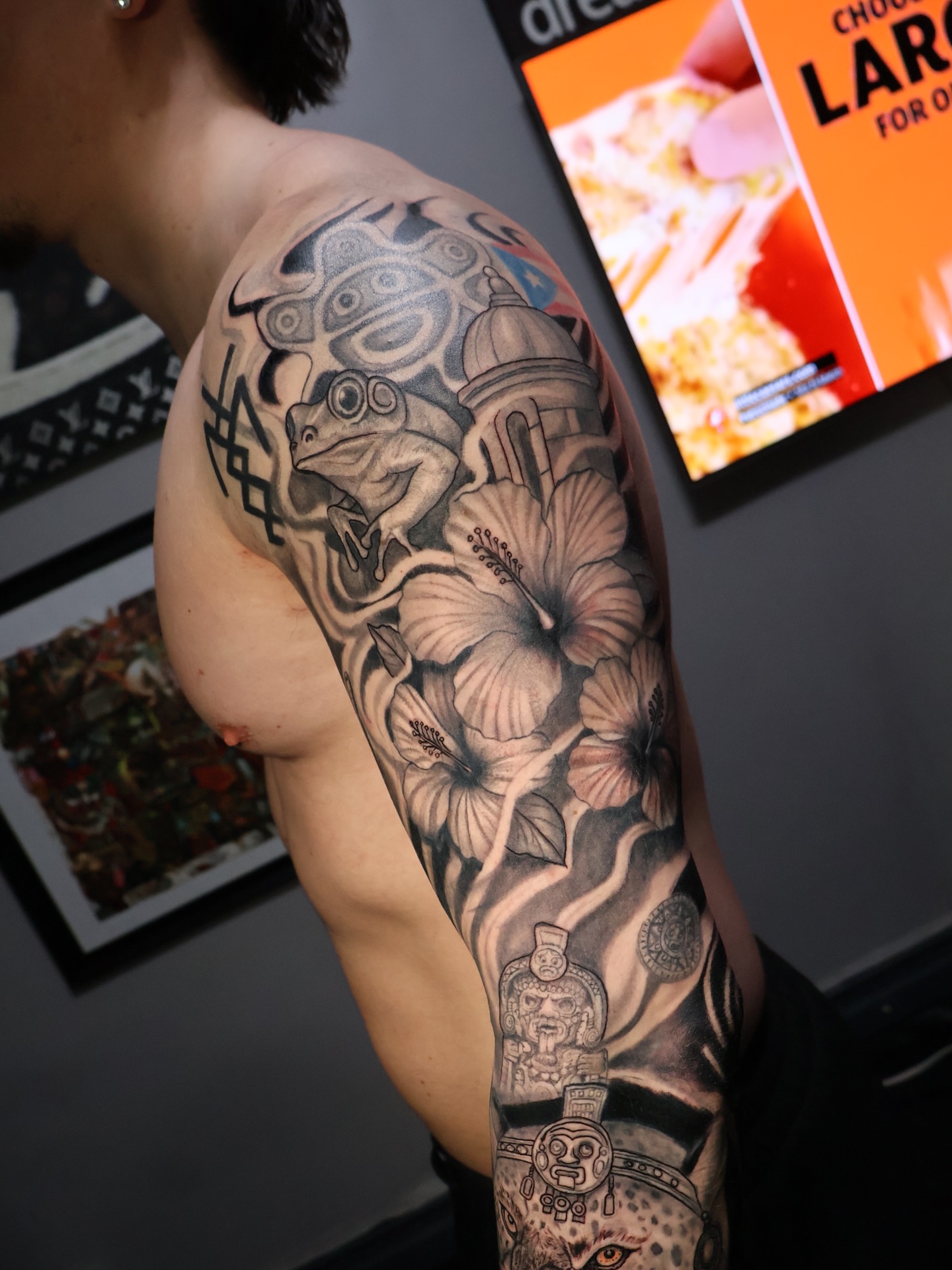 Floral and architectural geometric tattoo on the upper arm by German Patiño.