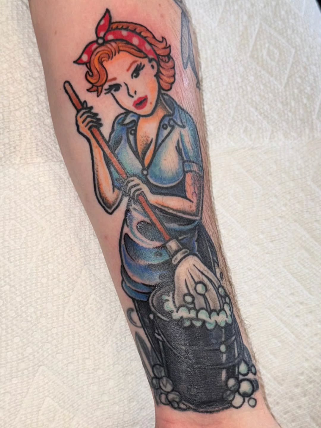 Housewife cleaning American traditional tattoo on the forearm by Tattoos by Reed Blount