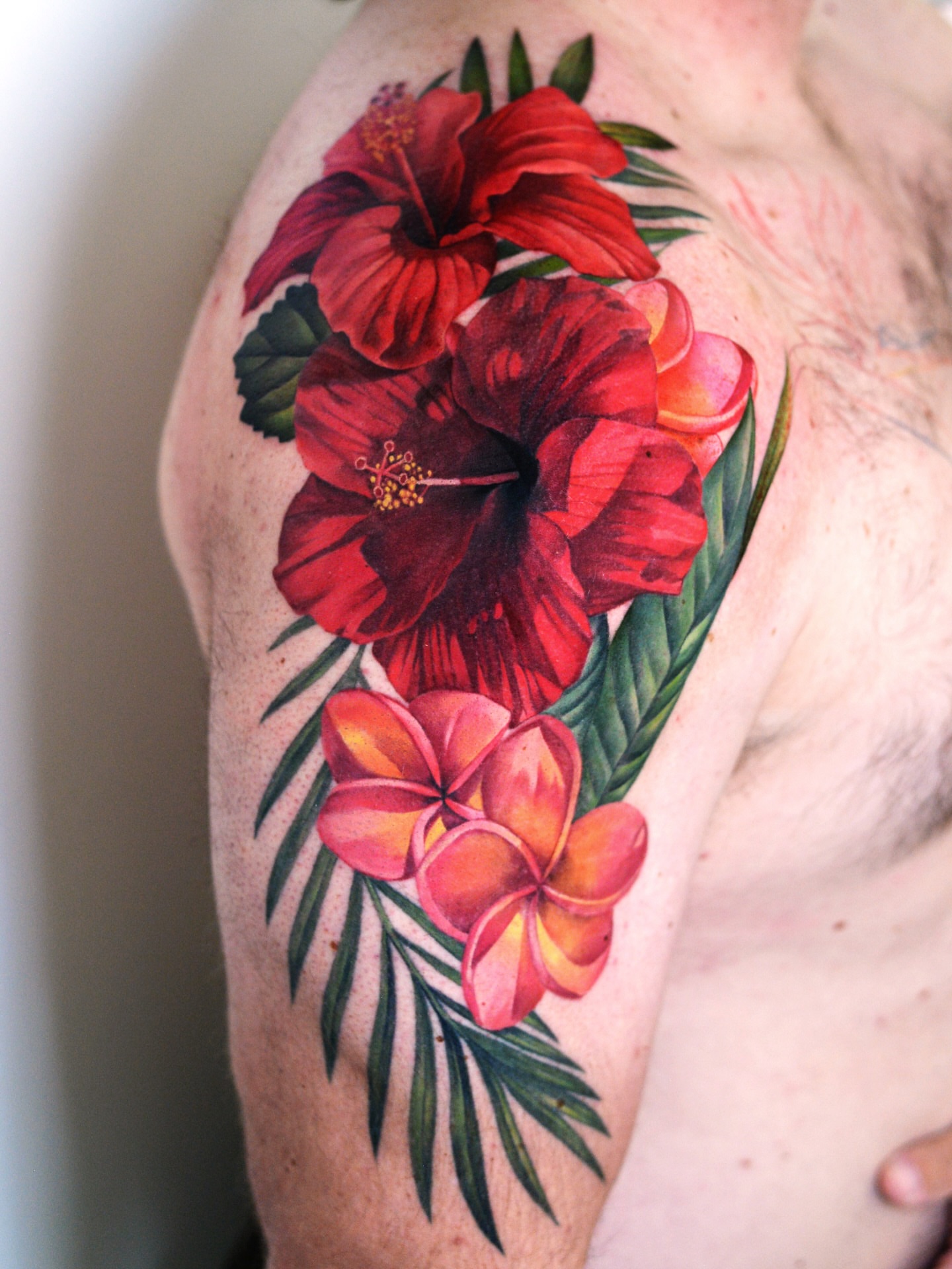 Hibiscus and plumeria realism tattoo on the shoulder by Joice Wang