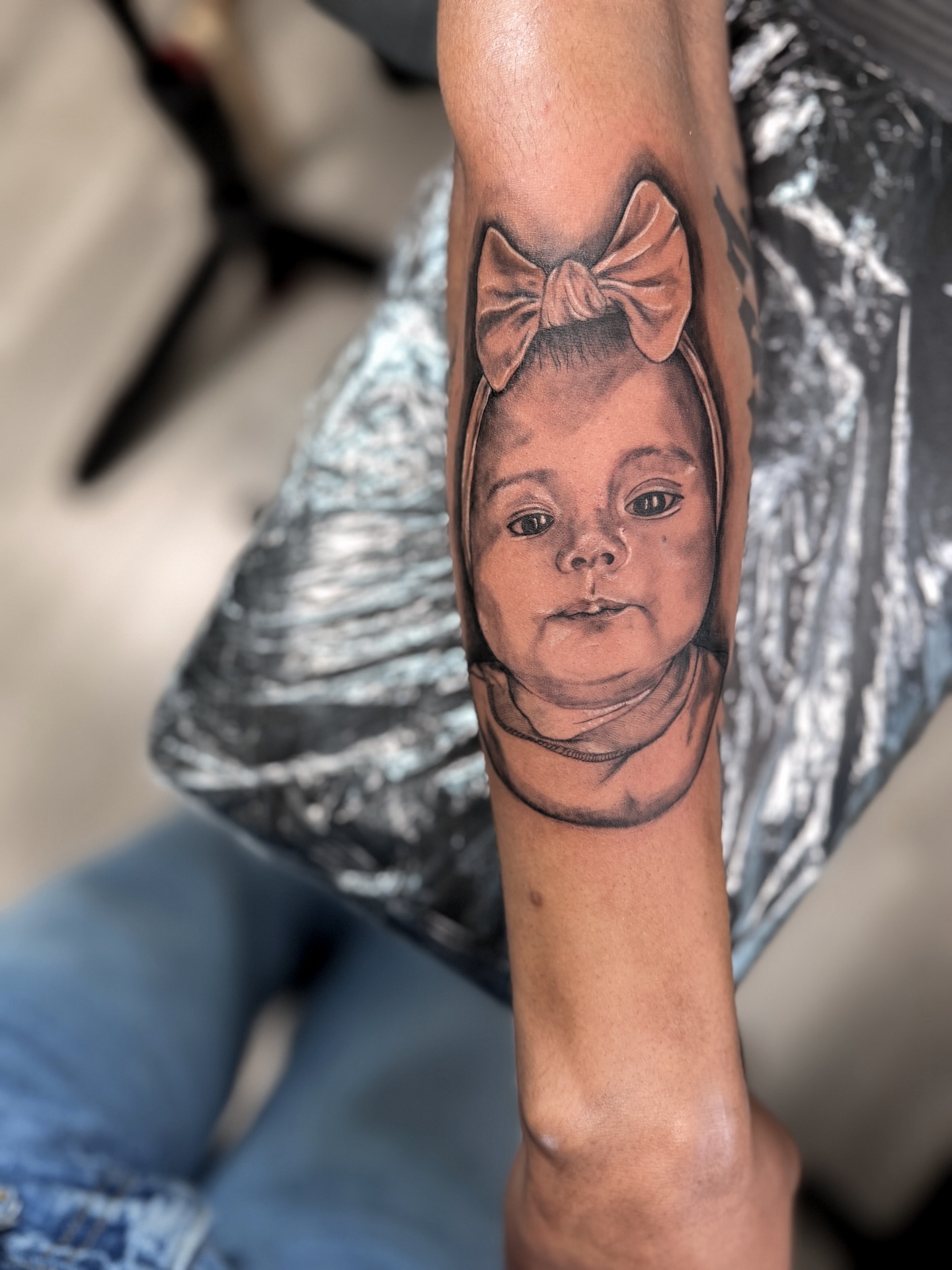 Child portrait realism tattoo on the forearm by Tatuajes Denver