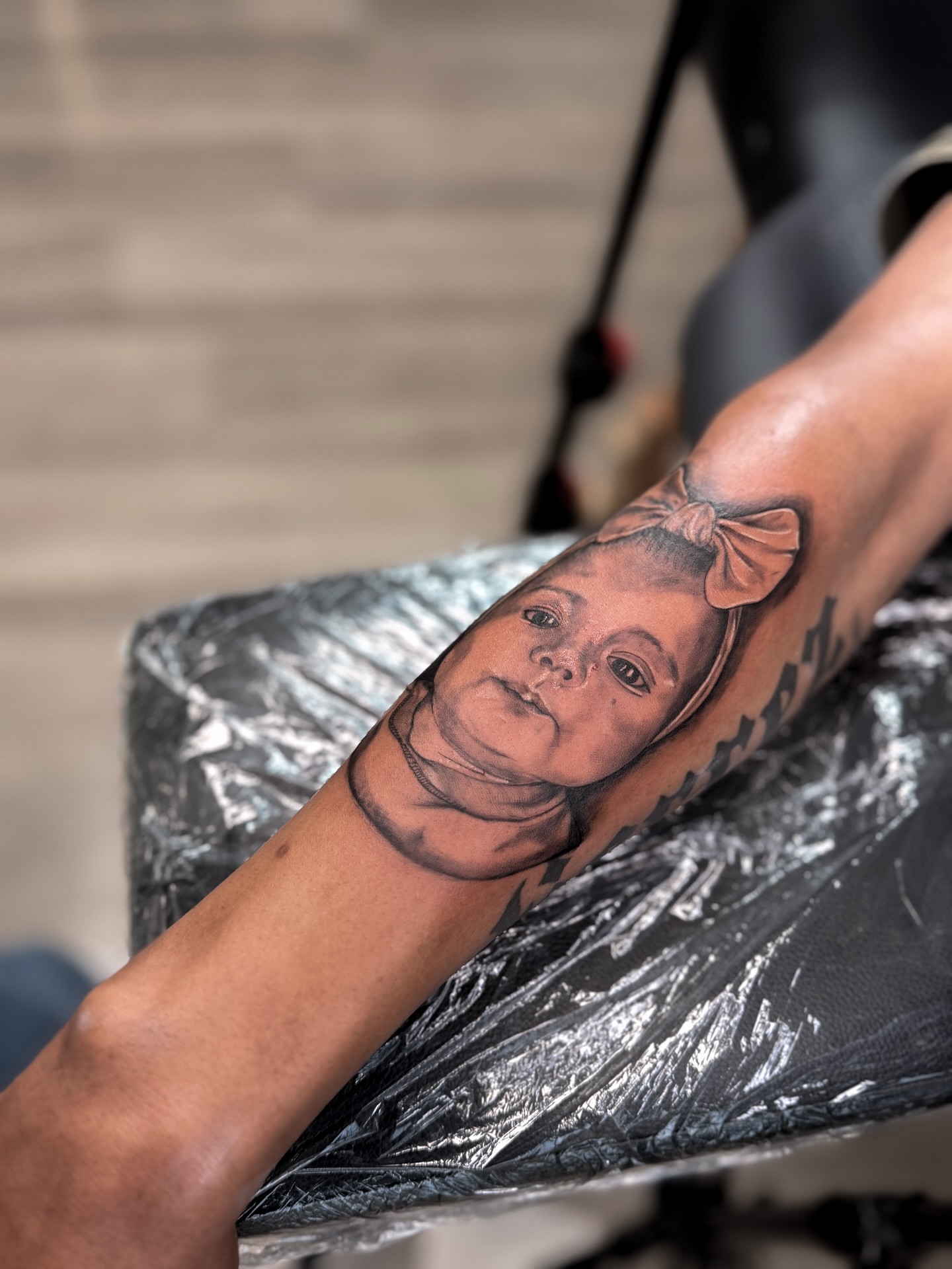 Child portrait realism tattoo on the forearm by Tatuajes Denver