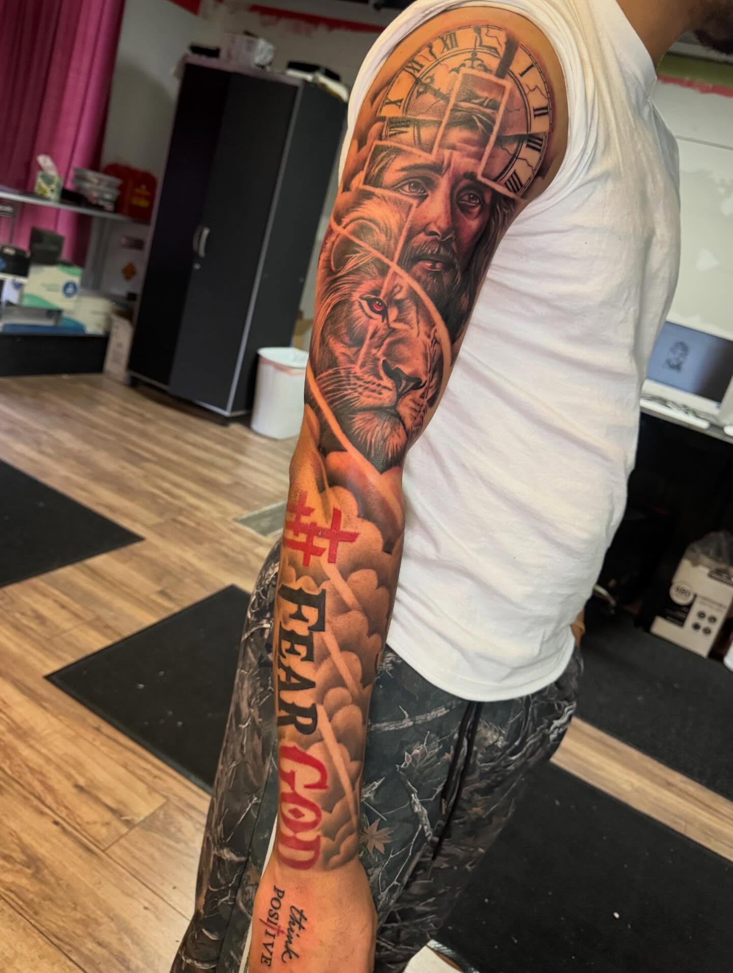 Lion and clock realism tattoo on the forearm by Cedric Fleming