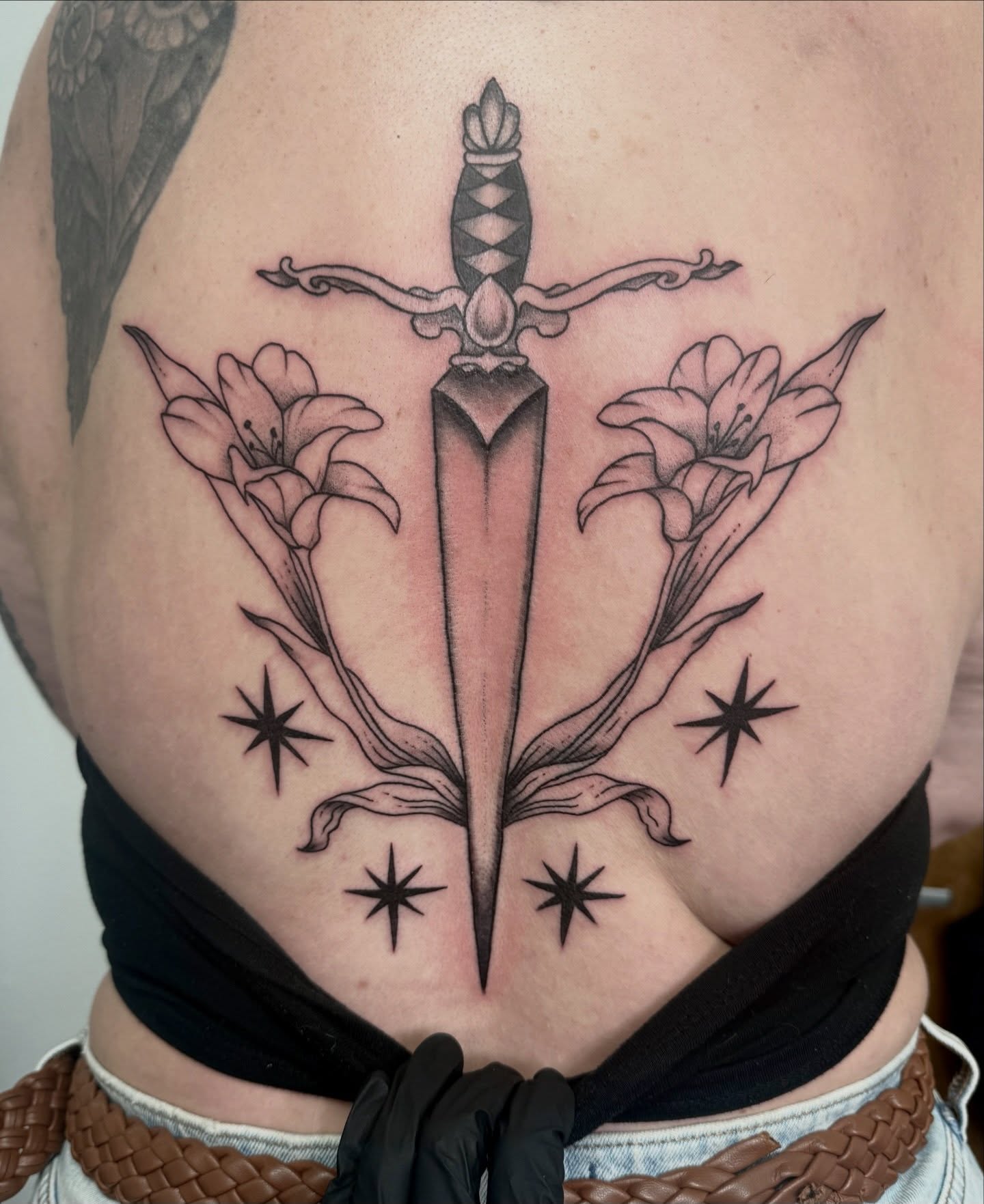 Sword and lilies black and grey tattoo on the torso by Shay - Mandeville Tattoo Artist