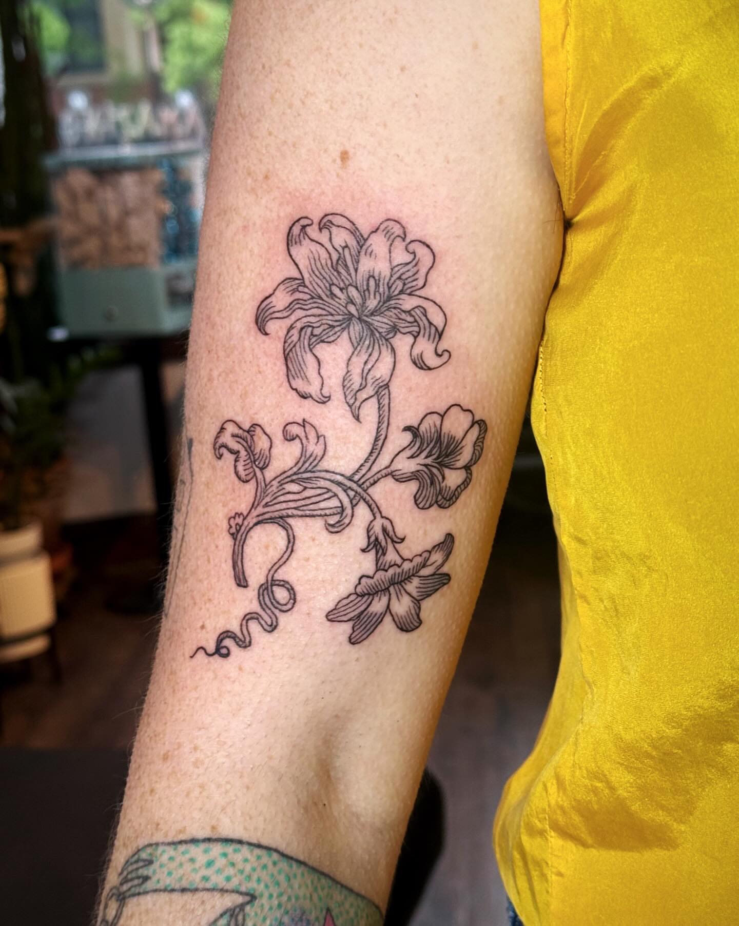 Lily and floral arrangement black and grey tattoo on the forearm by Luna Enriquez⚡️, Portland, Oregon
