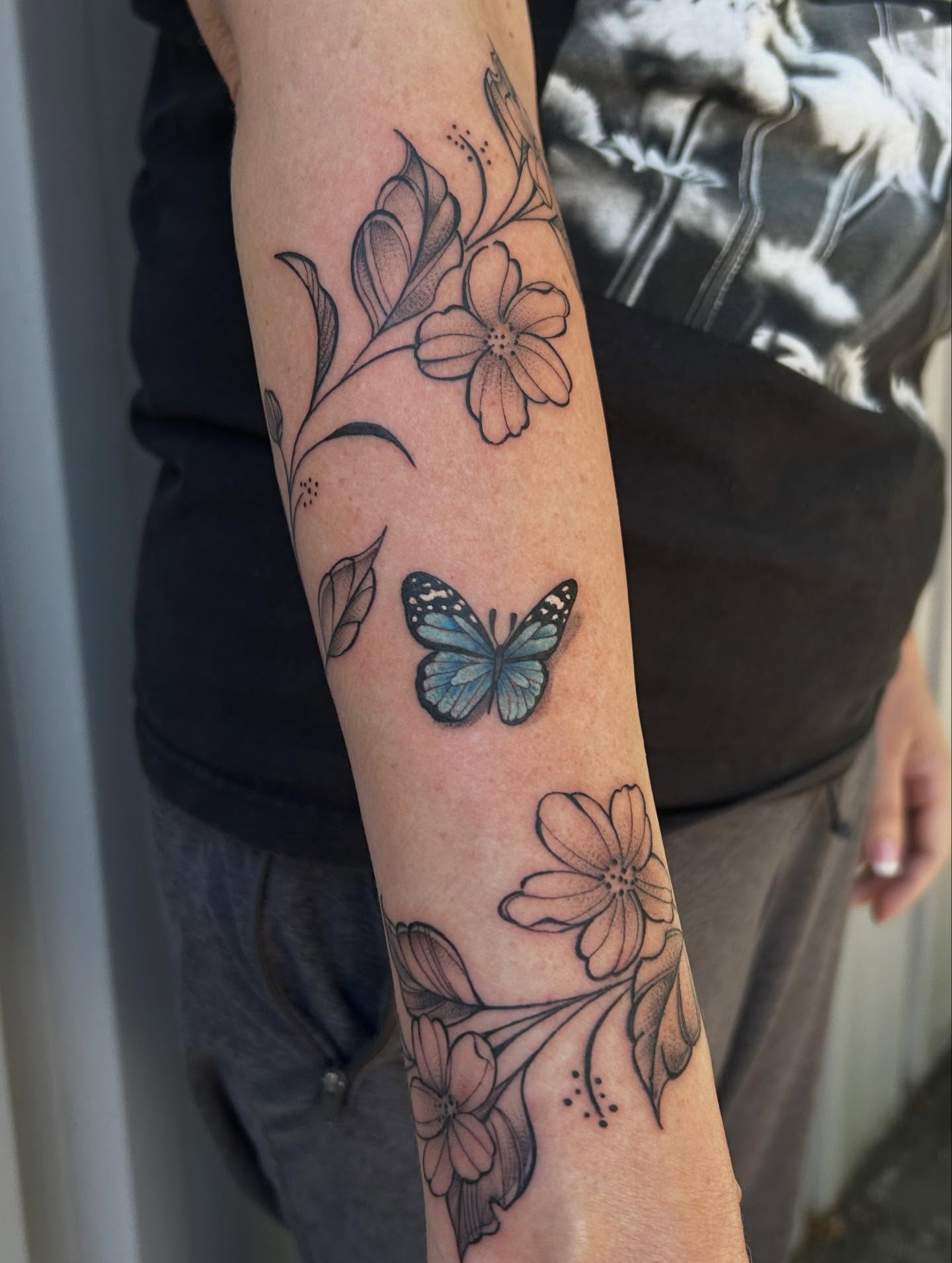 Butterfly and flowers dotwork tattoo on the forearm by Mayhem Andrews