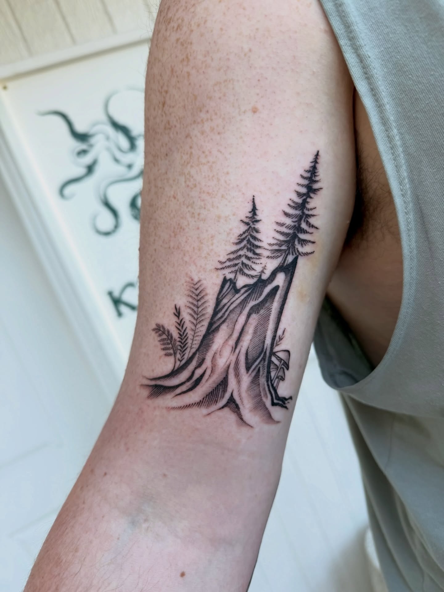 Pine trees and mountain realism tattoo on the forearm by Kingtide Ink