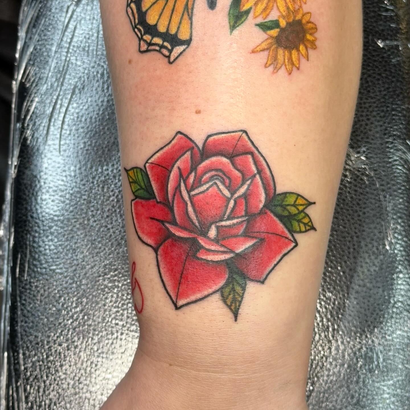 Red rose American traditional tattoo on the forearm by Nic
