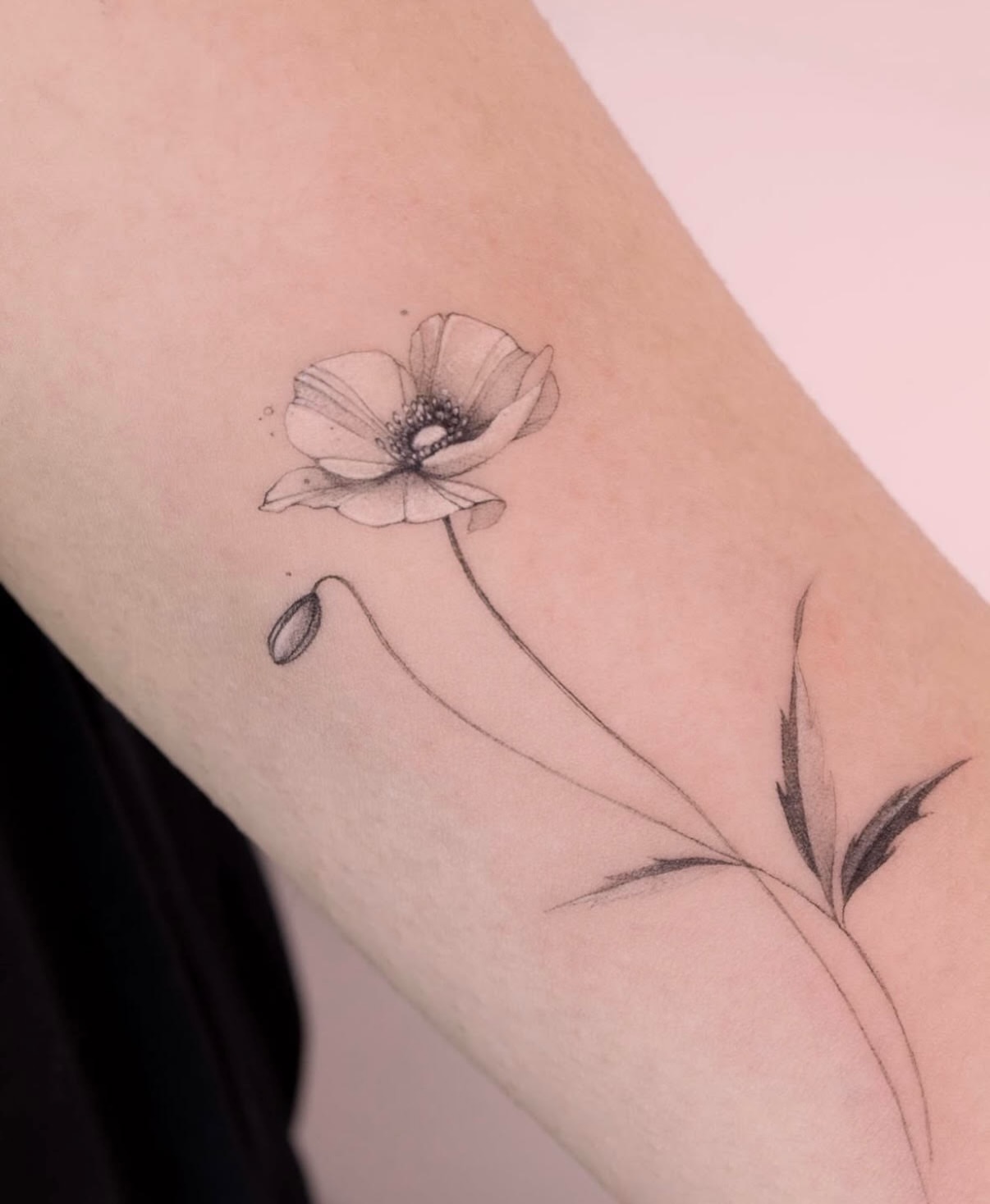 Poppy flower black and grey tattoo on the forearm by Tattooist hea