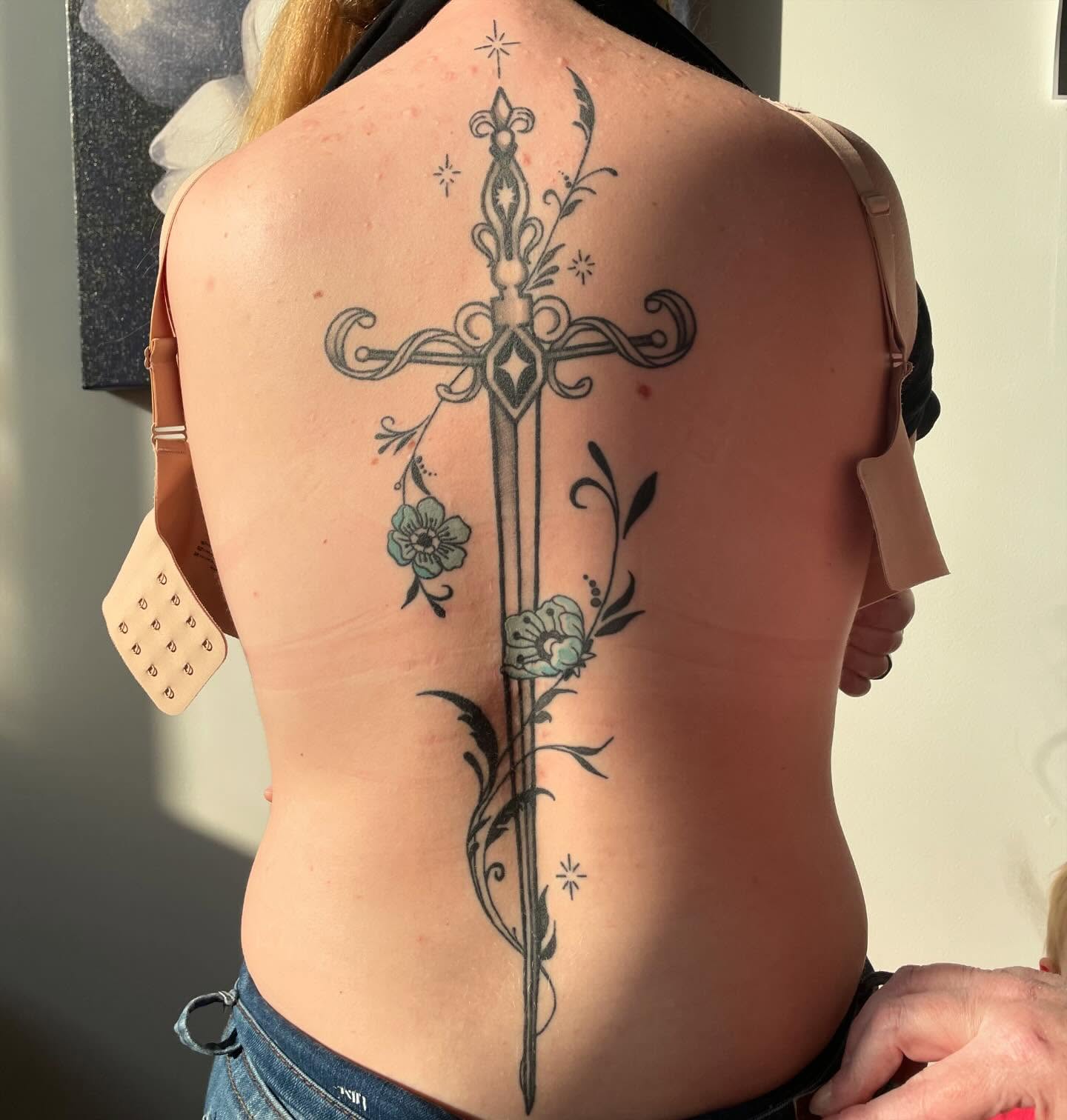 Cross with floral details ornamental tattoo on the back by Avalon Sable