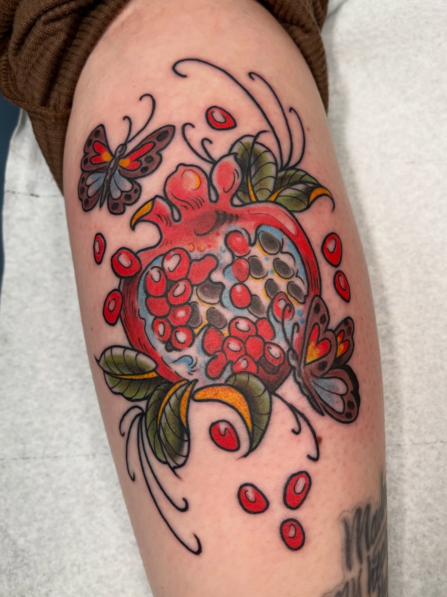 Pomegranate American traditional tattoo on the thigh by Allyson Blessing Tattoos