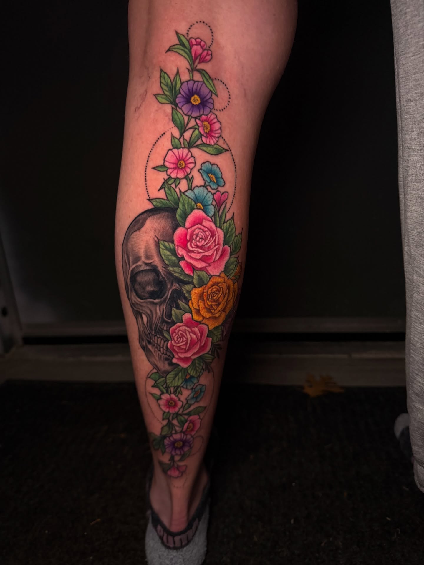 Skull and floral arrangement realism tattoo on the calf by Tyler Jewett