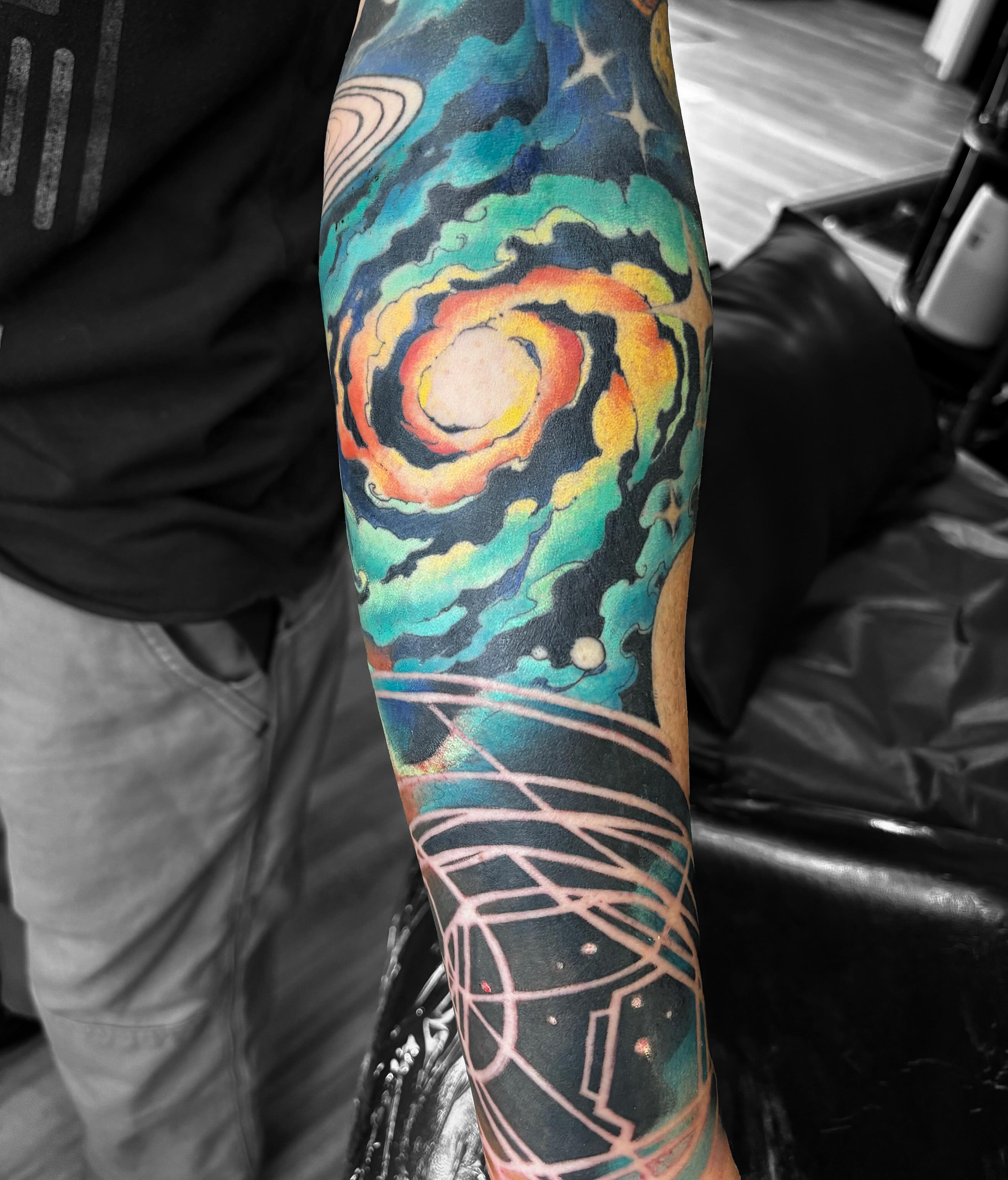 Space scene watercolor tattoo on the forearm by Alex
