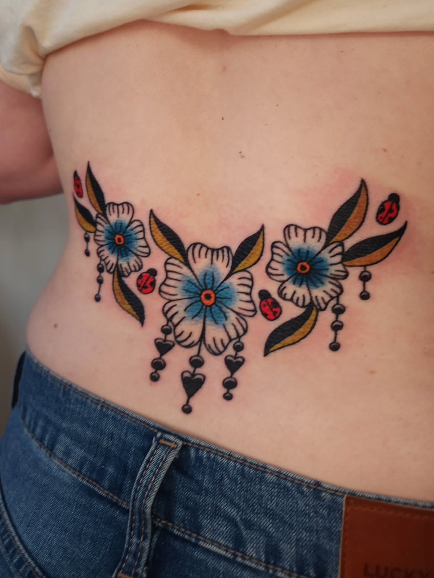 Floral arrangement American traditional tattoo on the ribs by Maxine Stewart