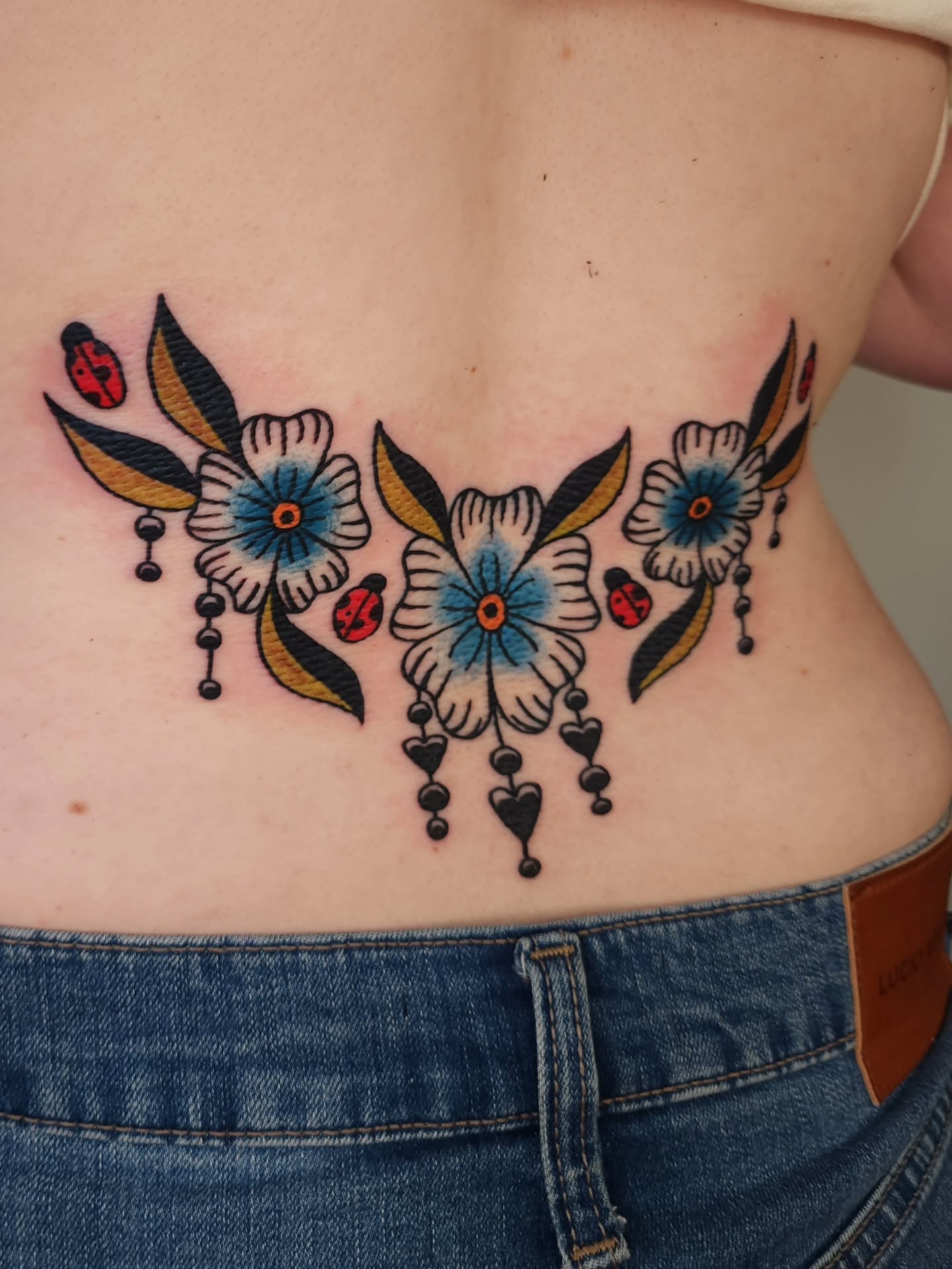 Floral arrangement American traditional tattoo on the ribs by Maxine Stewart