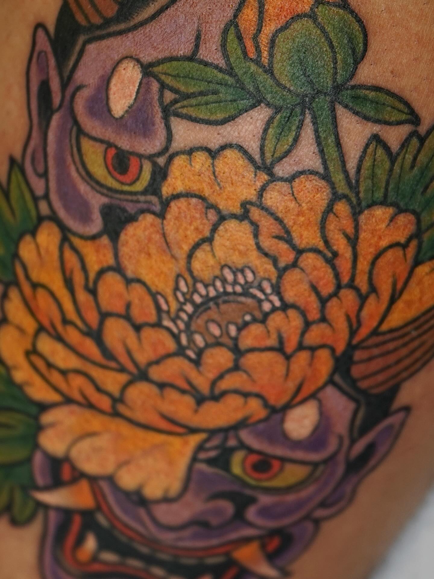 Cat and flower American traditional tattoo on the upper arm by Tyler Harrington