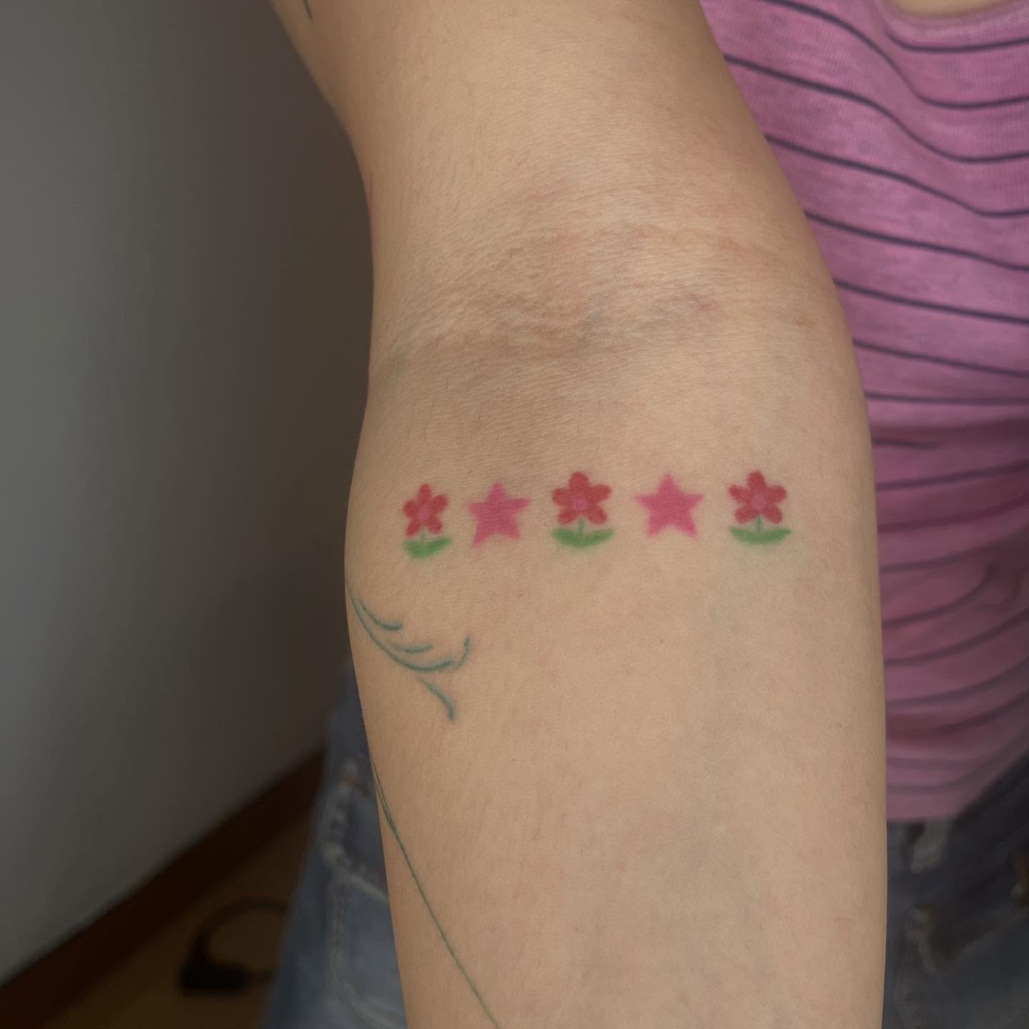 Five-pointed stars trash polka tattoo on the forearm by Jenna