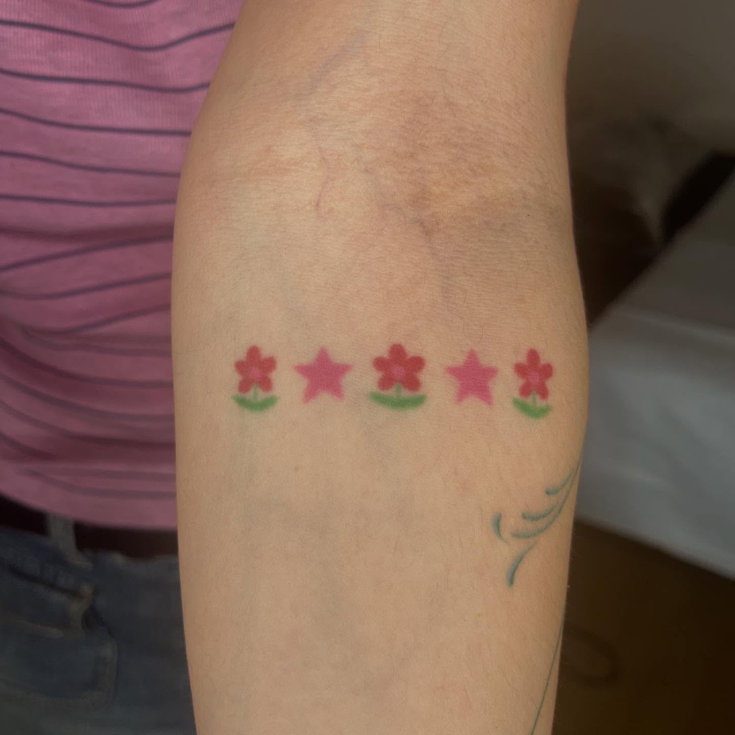 Five-pointed stars trash polka tattoo on the forearm by Jenna