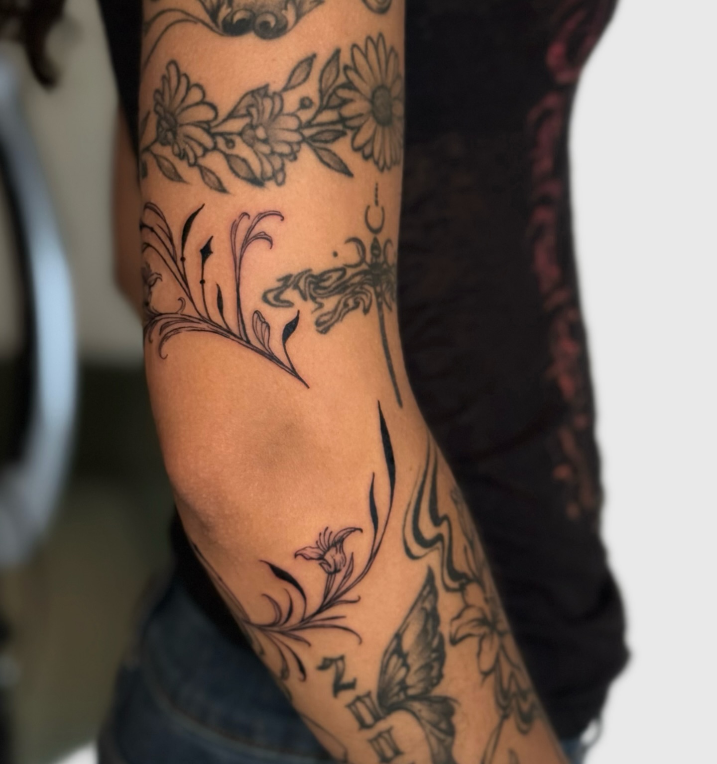 Floral and dragonfly black and grey tattoo on the forearm by Miami Tattoo Artist, Miami, Florida