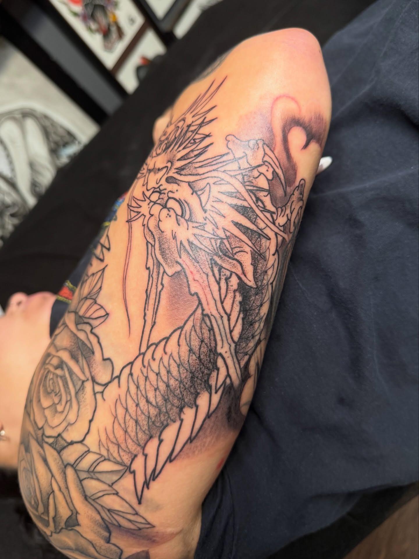 Dragon and roses dotwork tattoo on the forearm by Chris Cockrill
