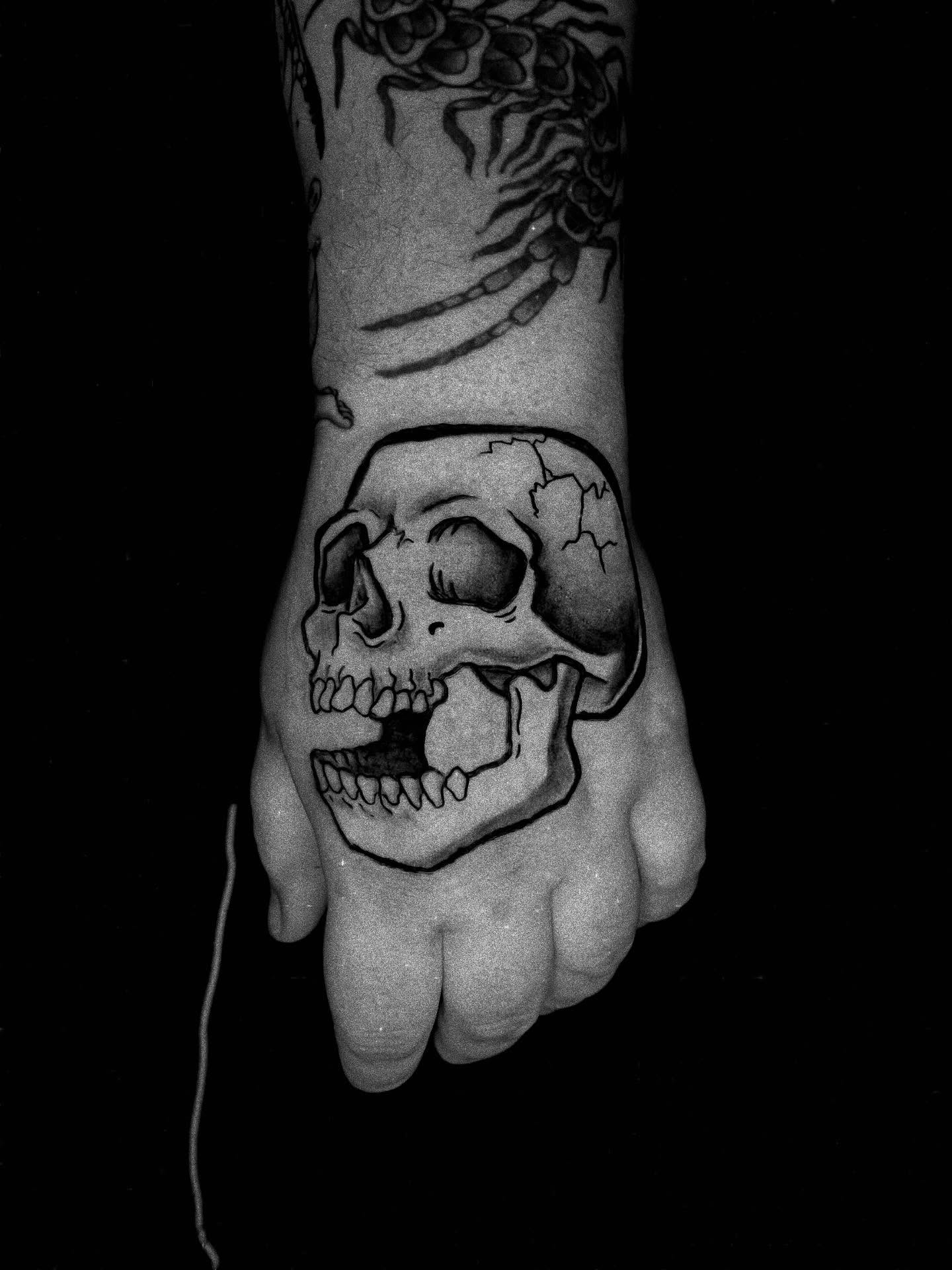Skull black and grey tattoo on the hand by Saint