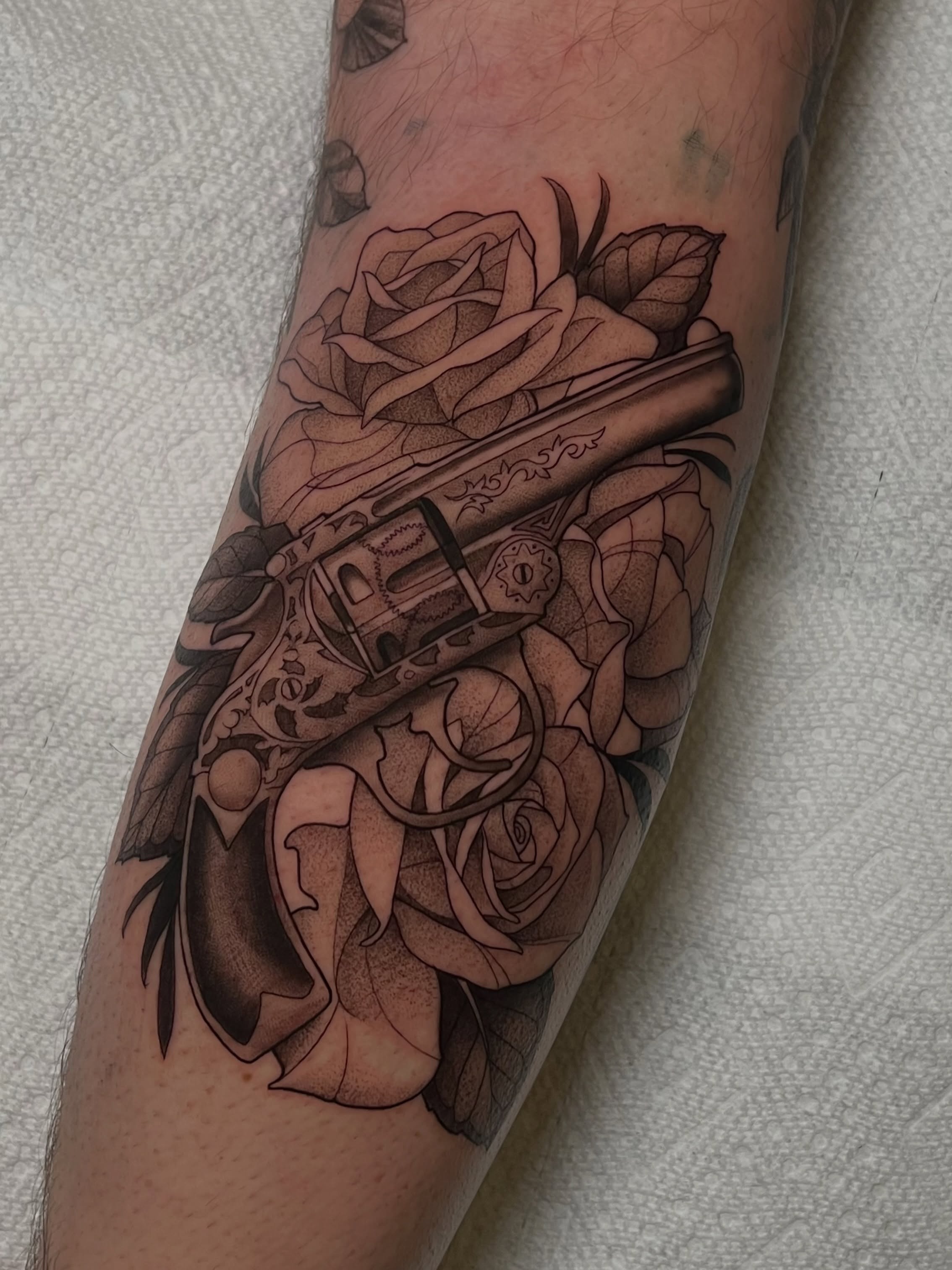 Revolver and roses tattoo on the forearm by Millie, Maryville, Tennessee