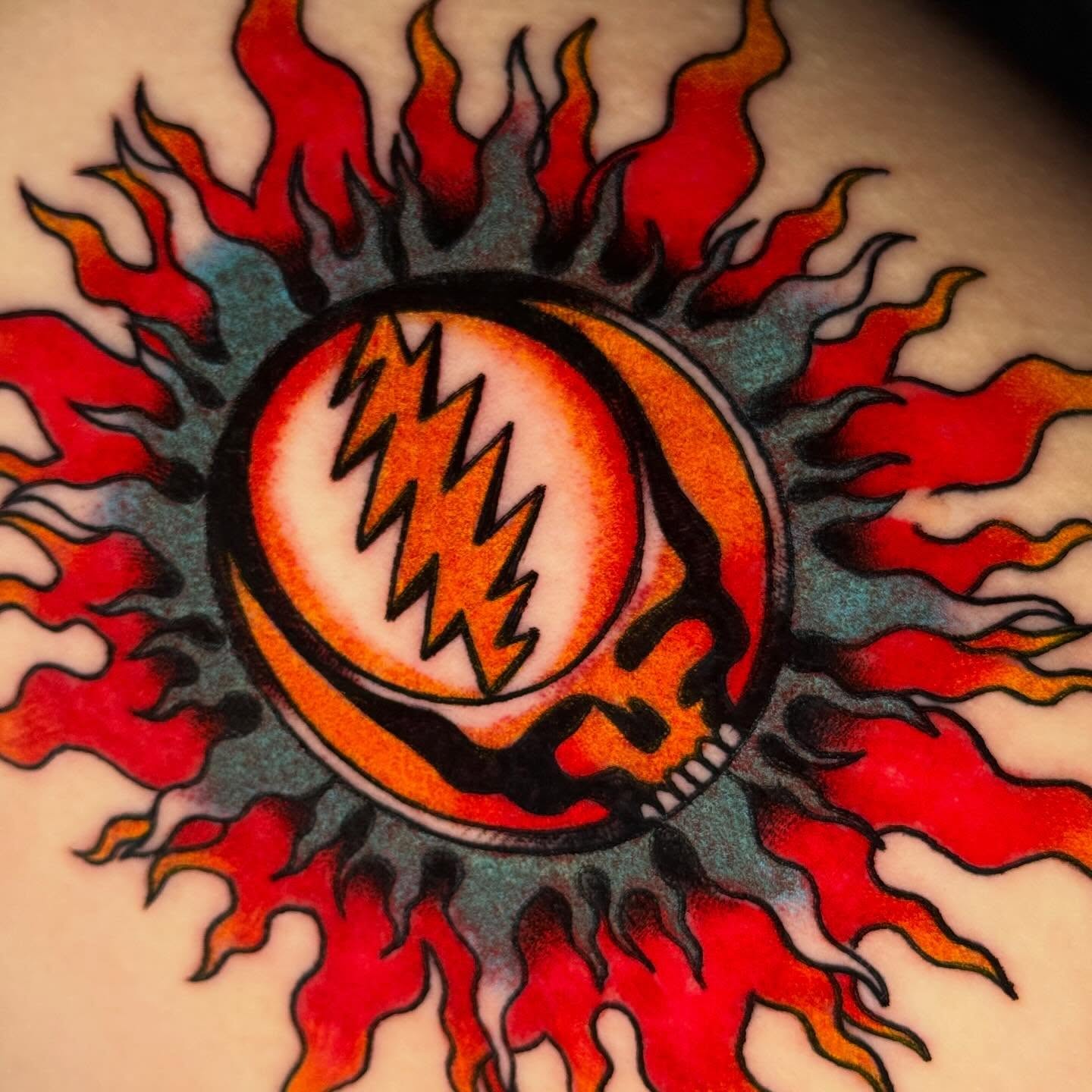 Grateful Dead lightning bolt American traditional tattoo on the torso by Mallory Brown