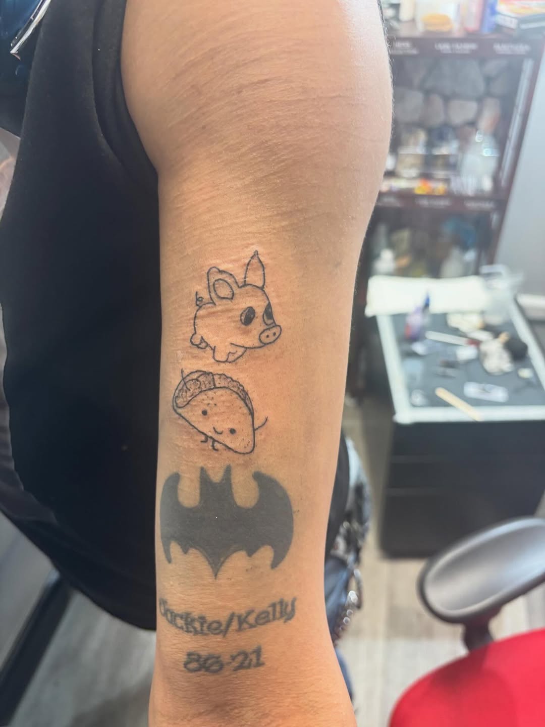 Pig, taco, and batman logo minimalist tattoo on the forearm by Syneca Wilson, Acton, Massachusetts