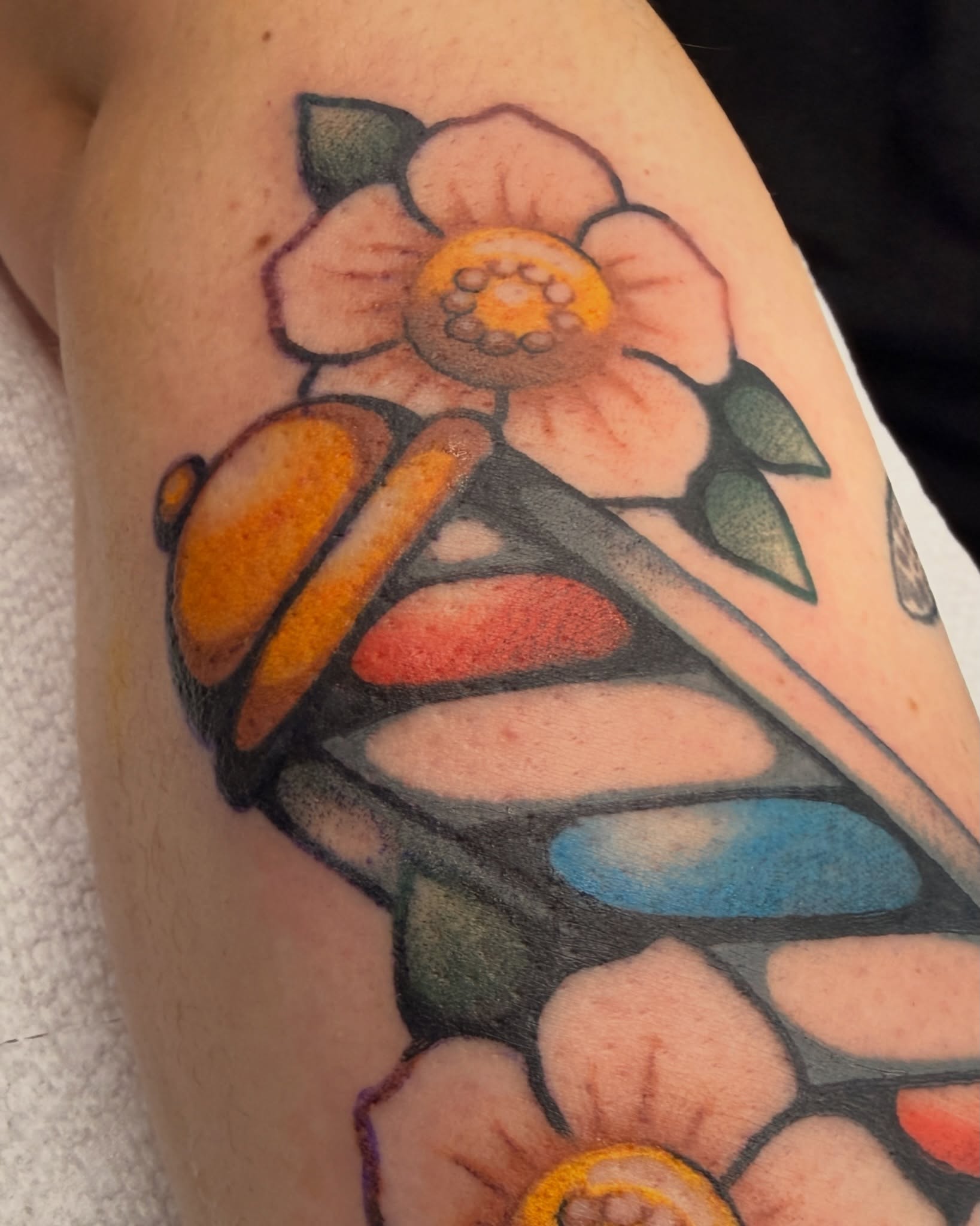 Butterfly and flower American traditional tattoo on the forearm by Penny D Tattoos