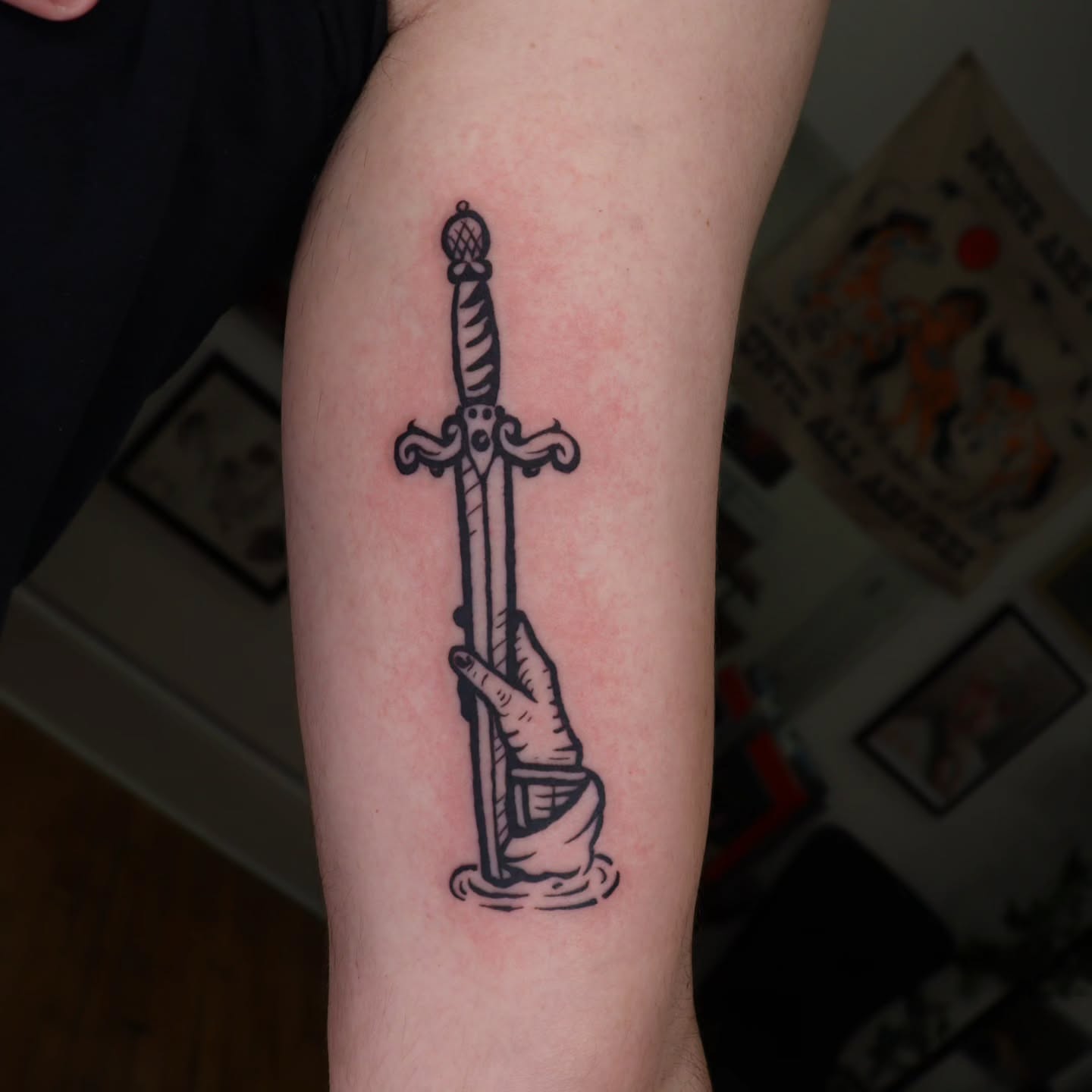 Sword and hand black and grey tattoo on the forearm by Veronika Lipchak