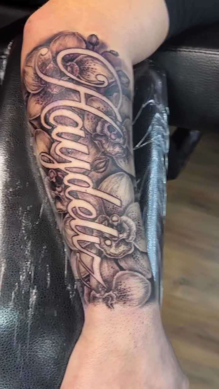 Name tattoo with floral elements Chicano tattoo on the forearm by TC 🧚🏽, Columbus, OH