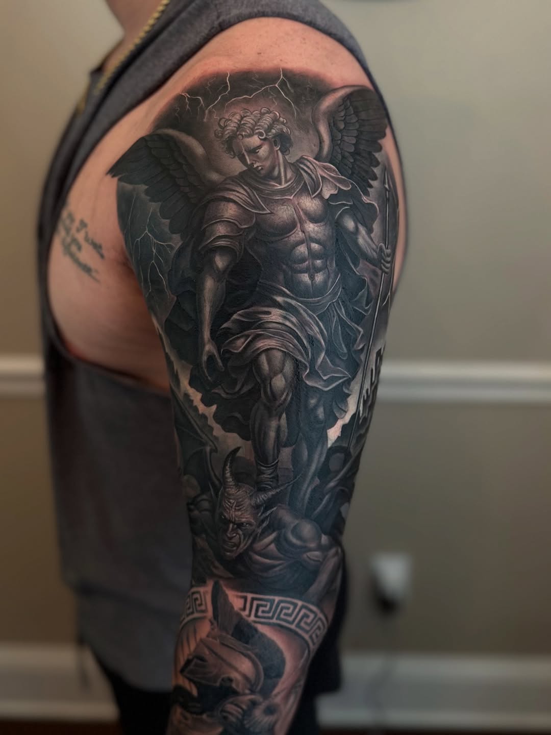 Archangel Michael battling a demon realism tattoo on the upper arm by Angels tattoo