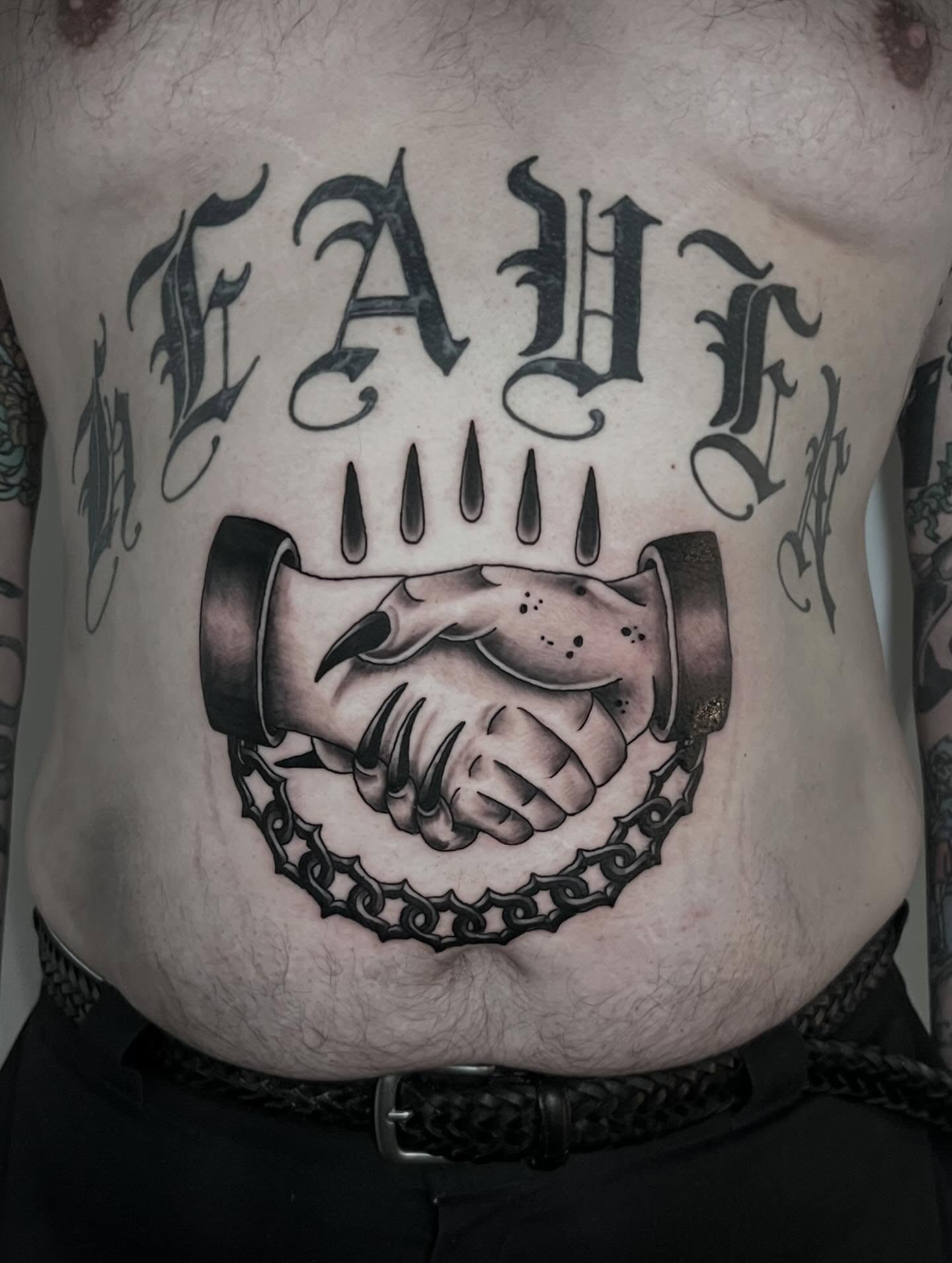 Handshake with chain realism tattoo on the torso by Eoghann McGregor