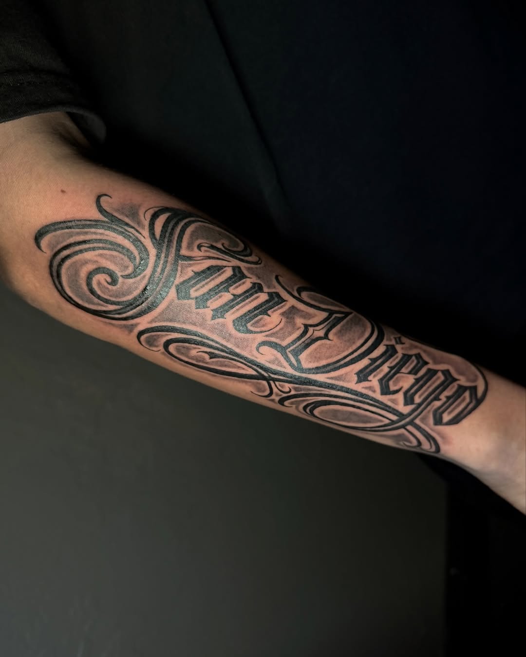 Script lettering Chicano tattoo on the forearm by jayla pantig