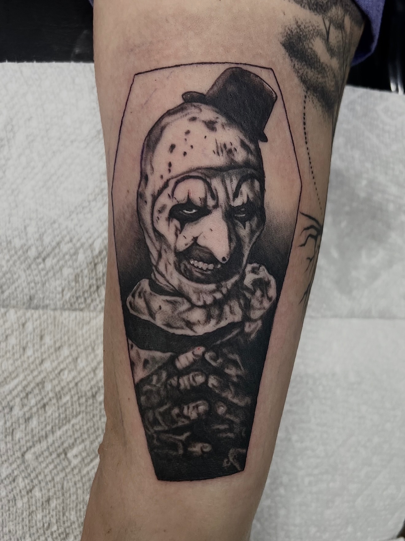 Clown realism tattoo on the forearm by Josh Kronauer