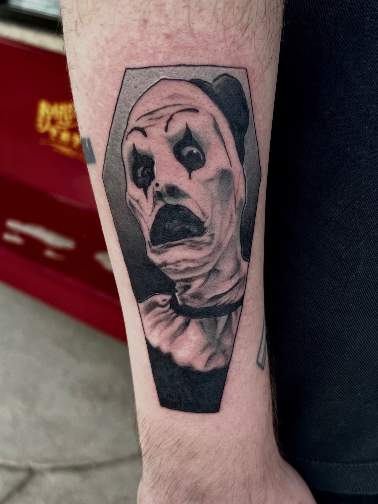 Clown realism tattoo on the forearm by Josh Kronauer
