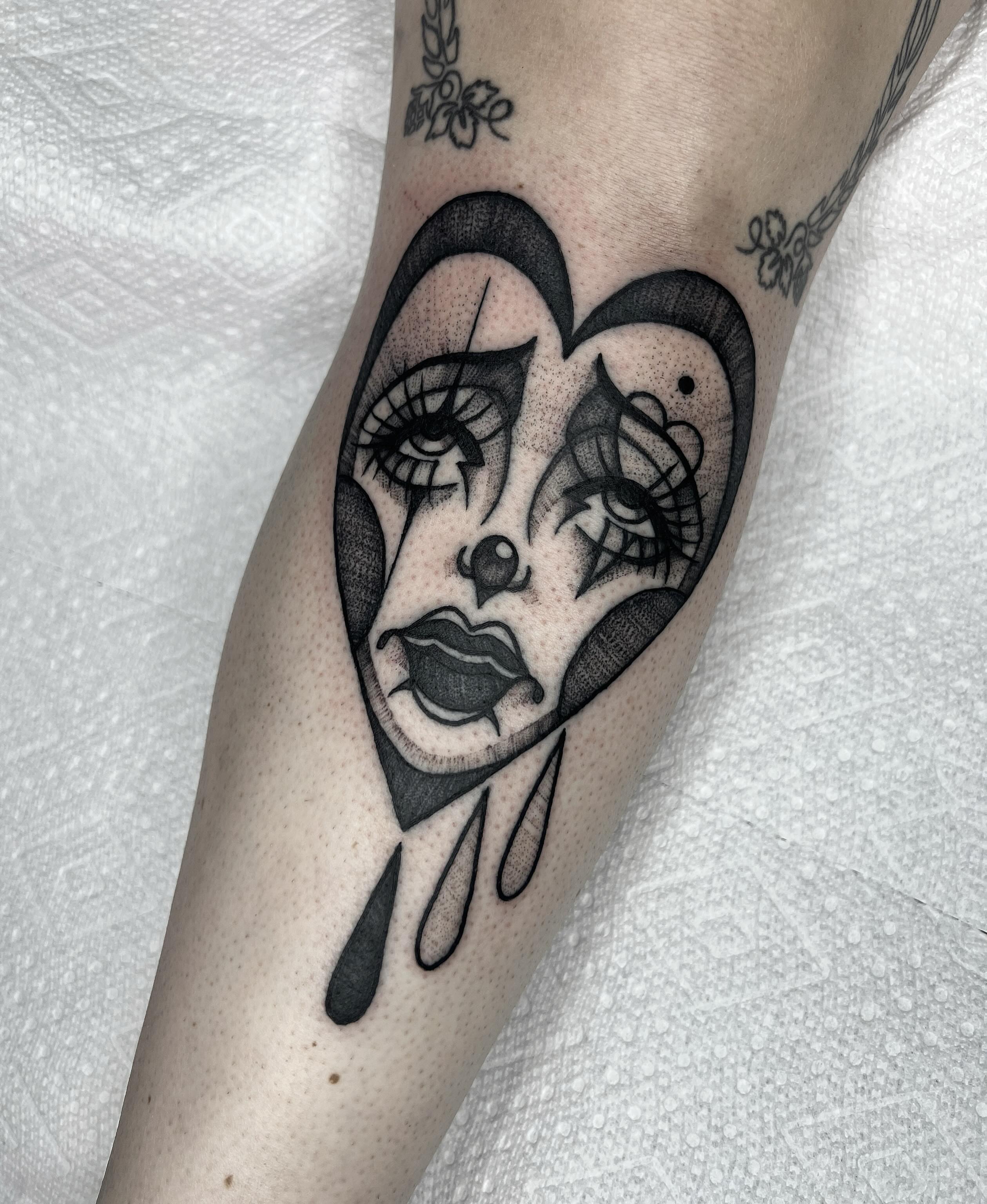 Abstract face dotwork tattoo on the forearm by Harlee Hornsby