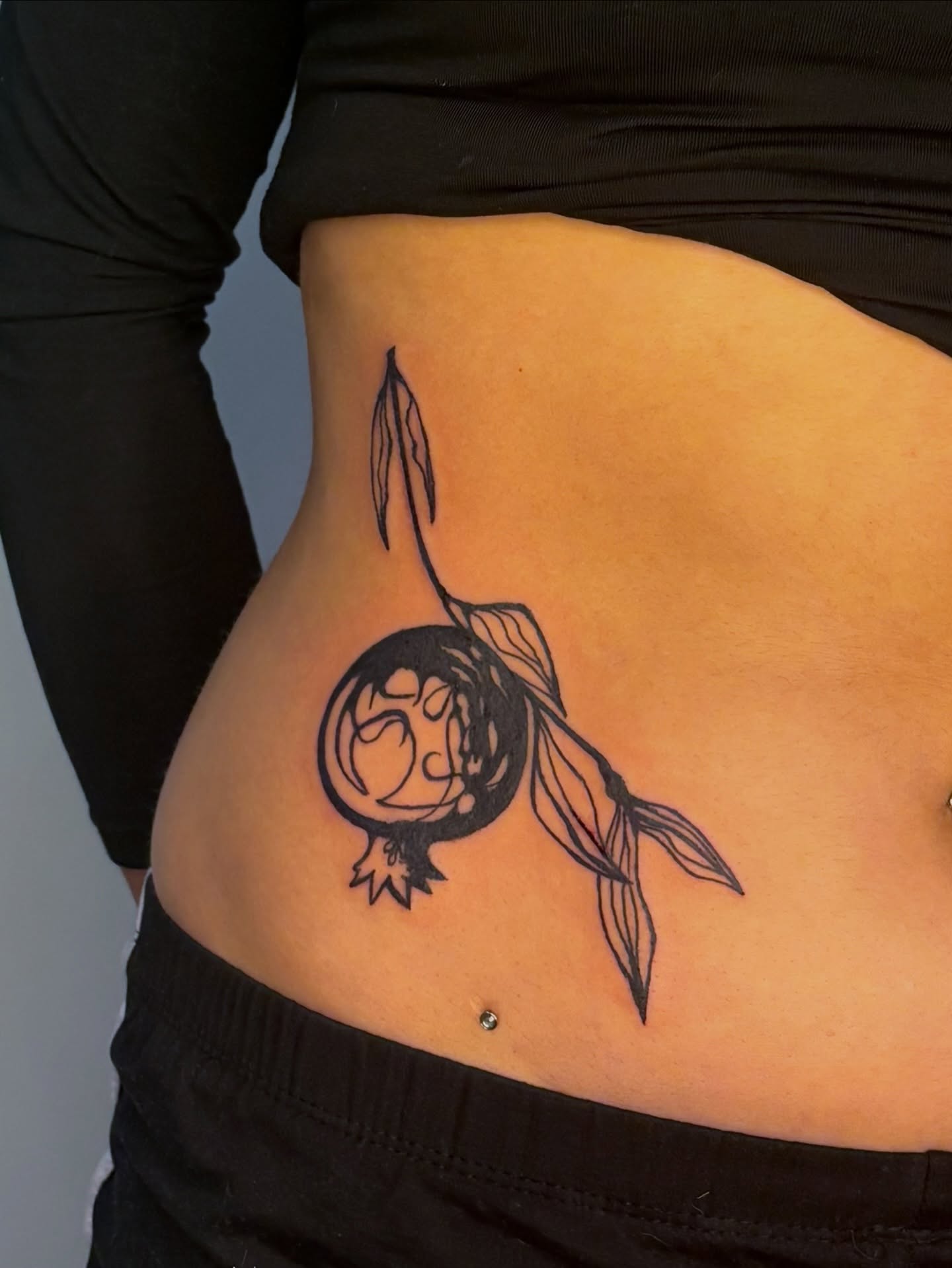 Pomegranate black and grey tattoo on the ribs by Sarah