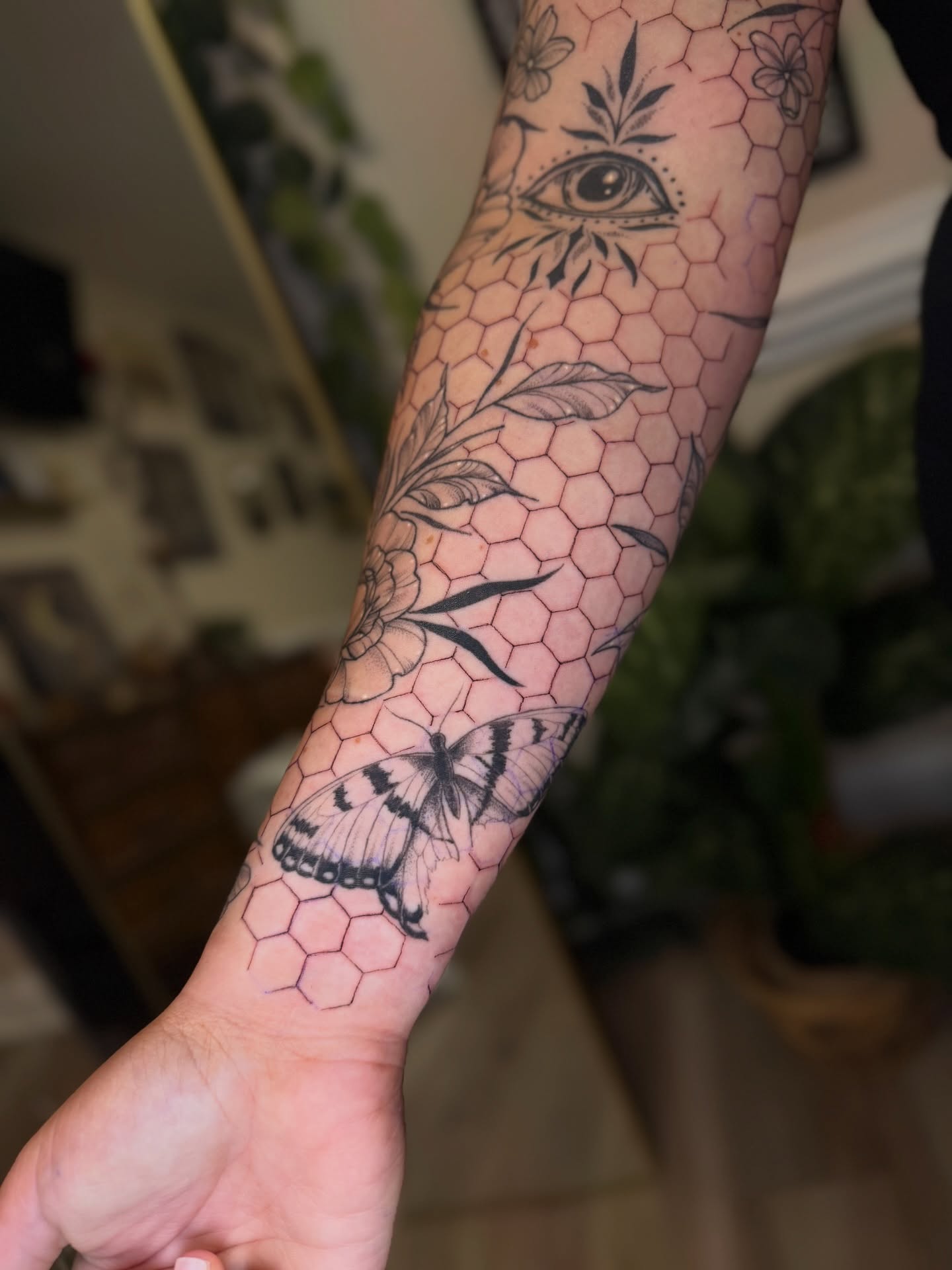 Butterfly and floral geometric tattoo on the forearm by McKenna