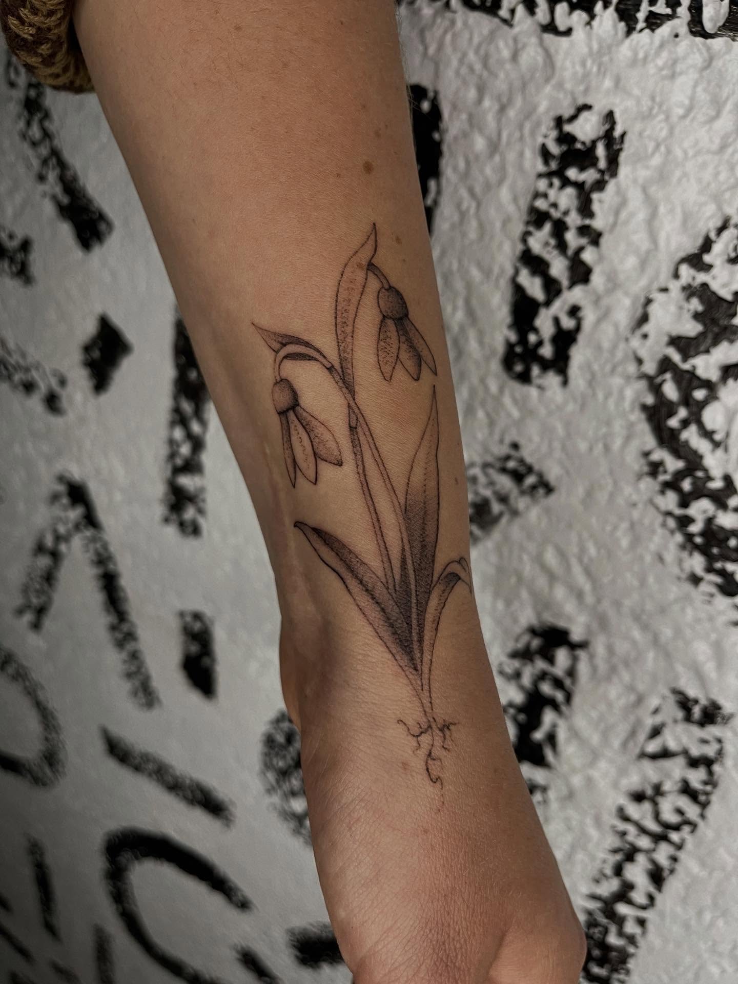 Snowdrops black and grey tattoo on the forearm by Victoria Irula