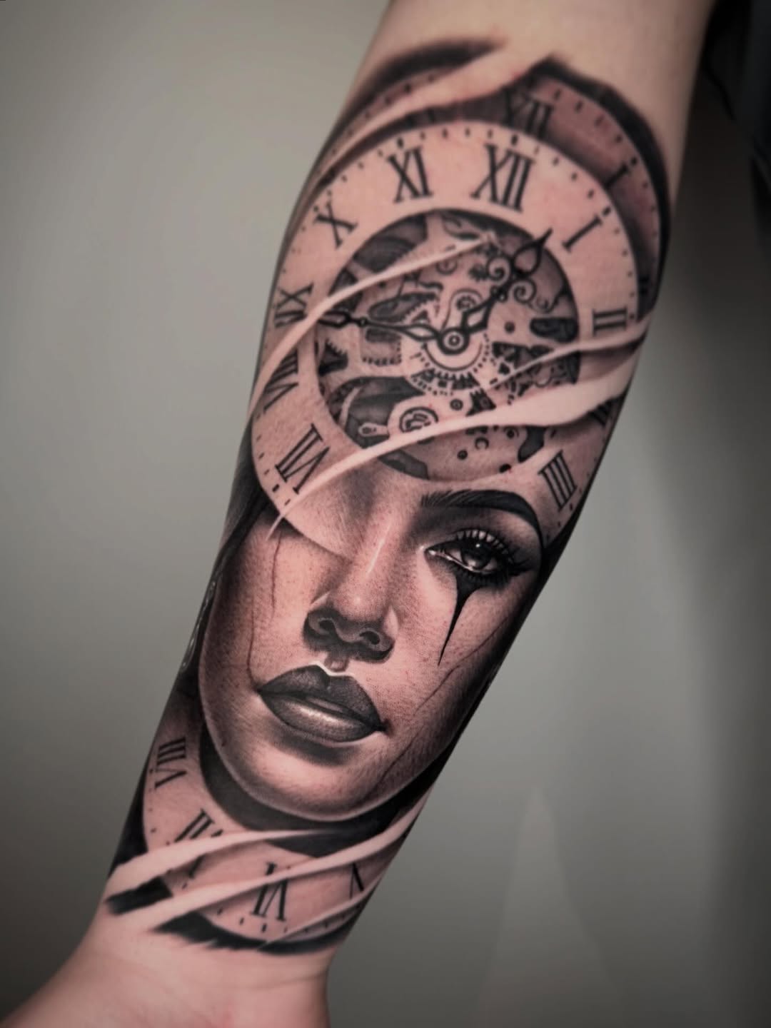 Woman's face with clockwork realism tattoo on the forearm by David Torres