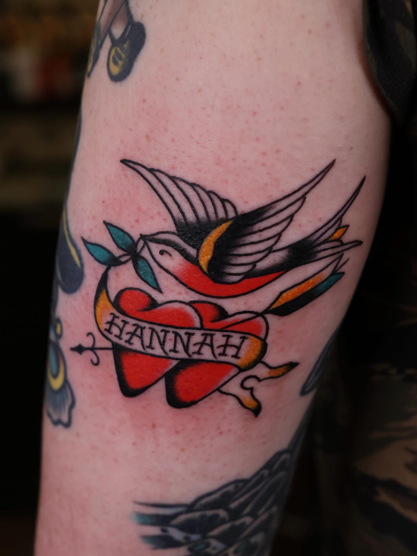 Swallow and heart American traditional tattoo on the forearm by Justin Rakowski