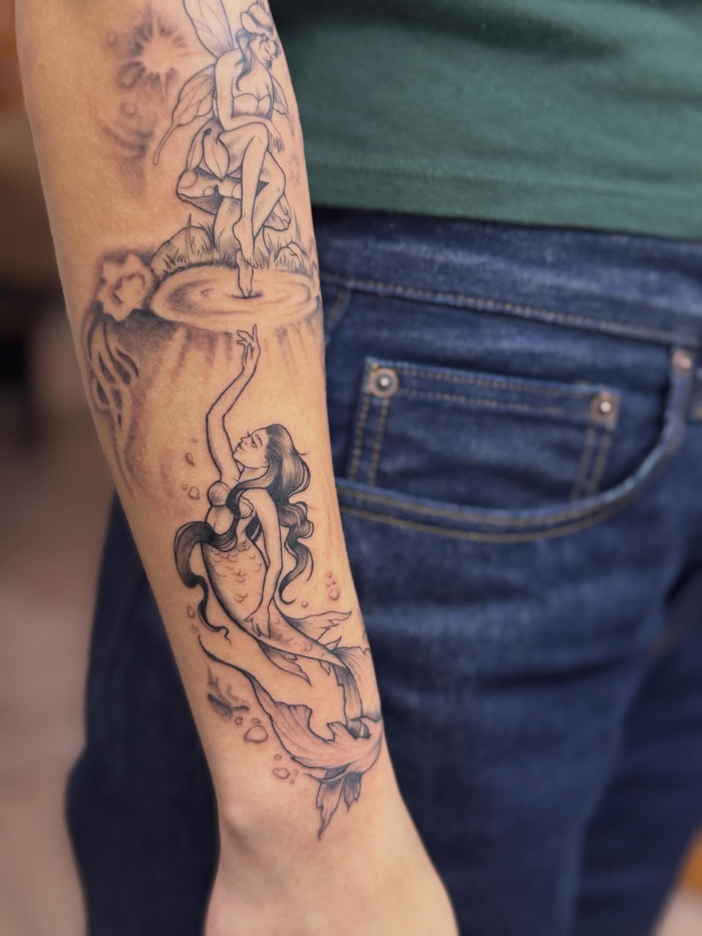 Mermaid and fairy black and grey tattoo on the forearm by Rebecca Rose