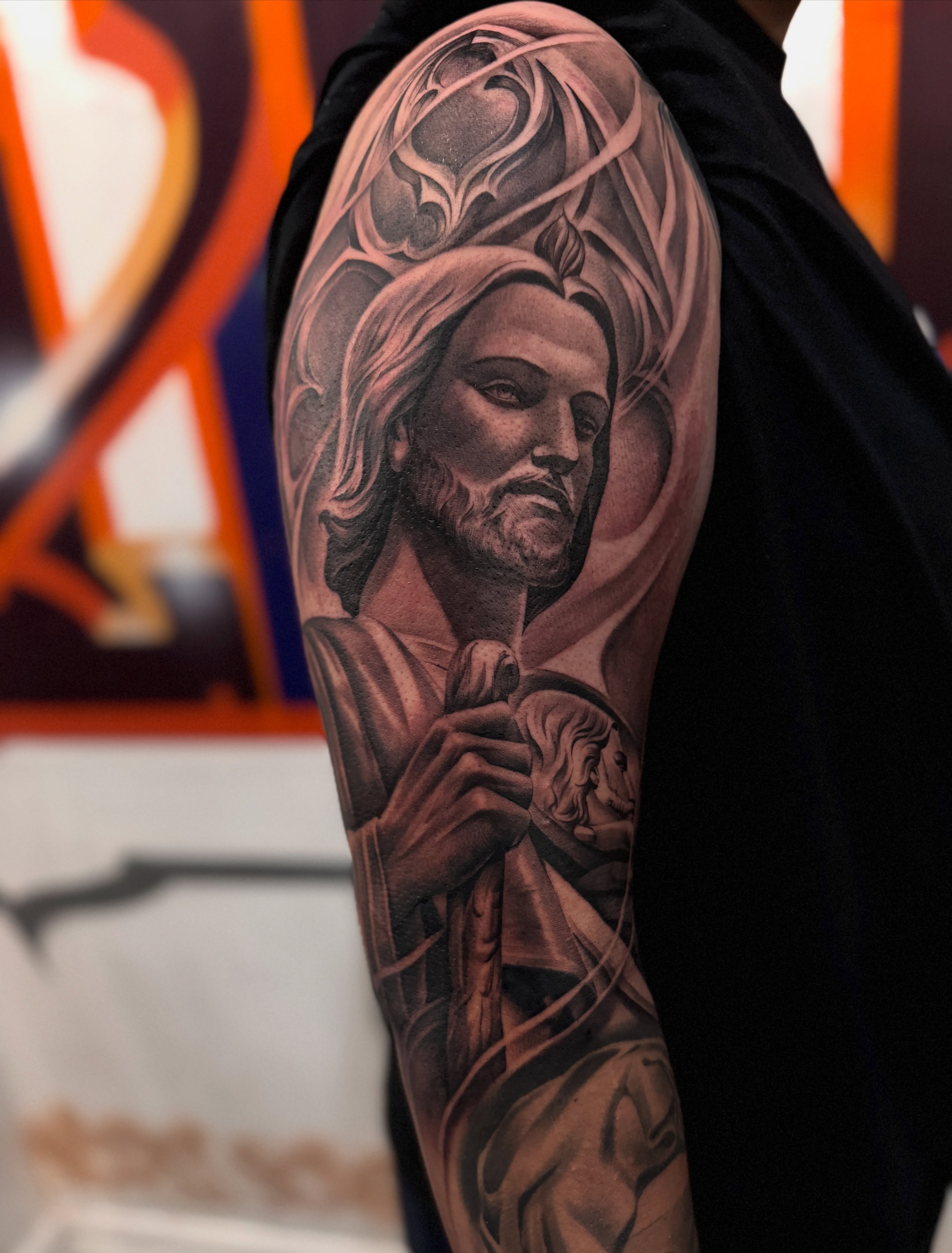 Religious figure realism tattoo on the forearm by tombstone
