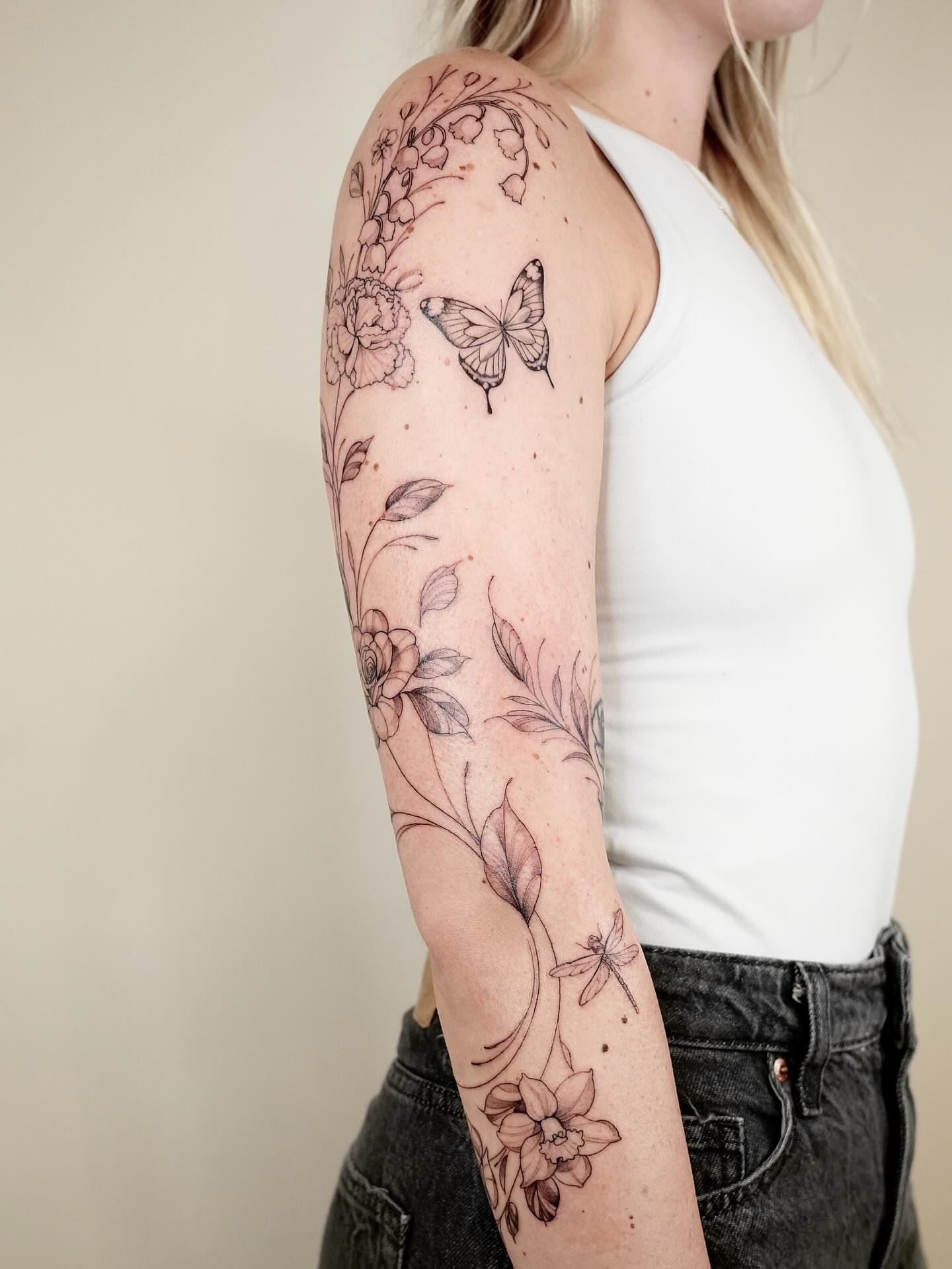 Floral and butterfly black and grey tattoo on the forearm by Marianna D D King