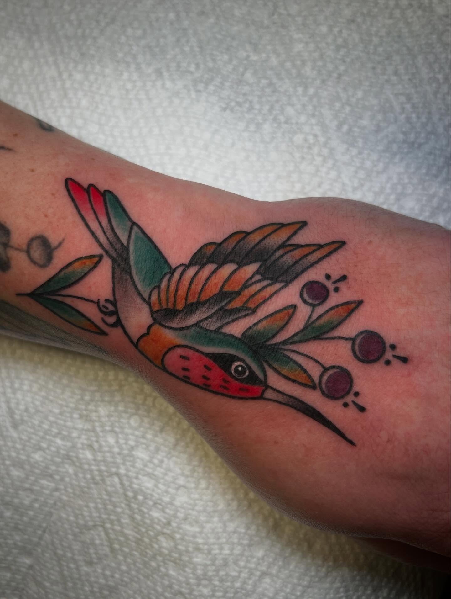 Bird and floral American traditional tattoo on the forearm by Katie Ann Tattoos