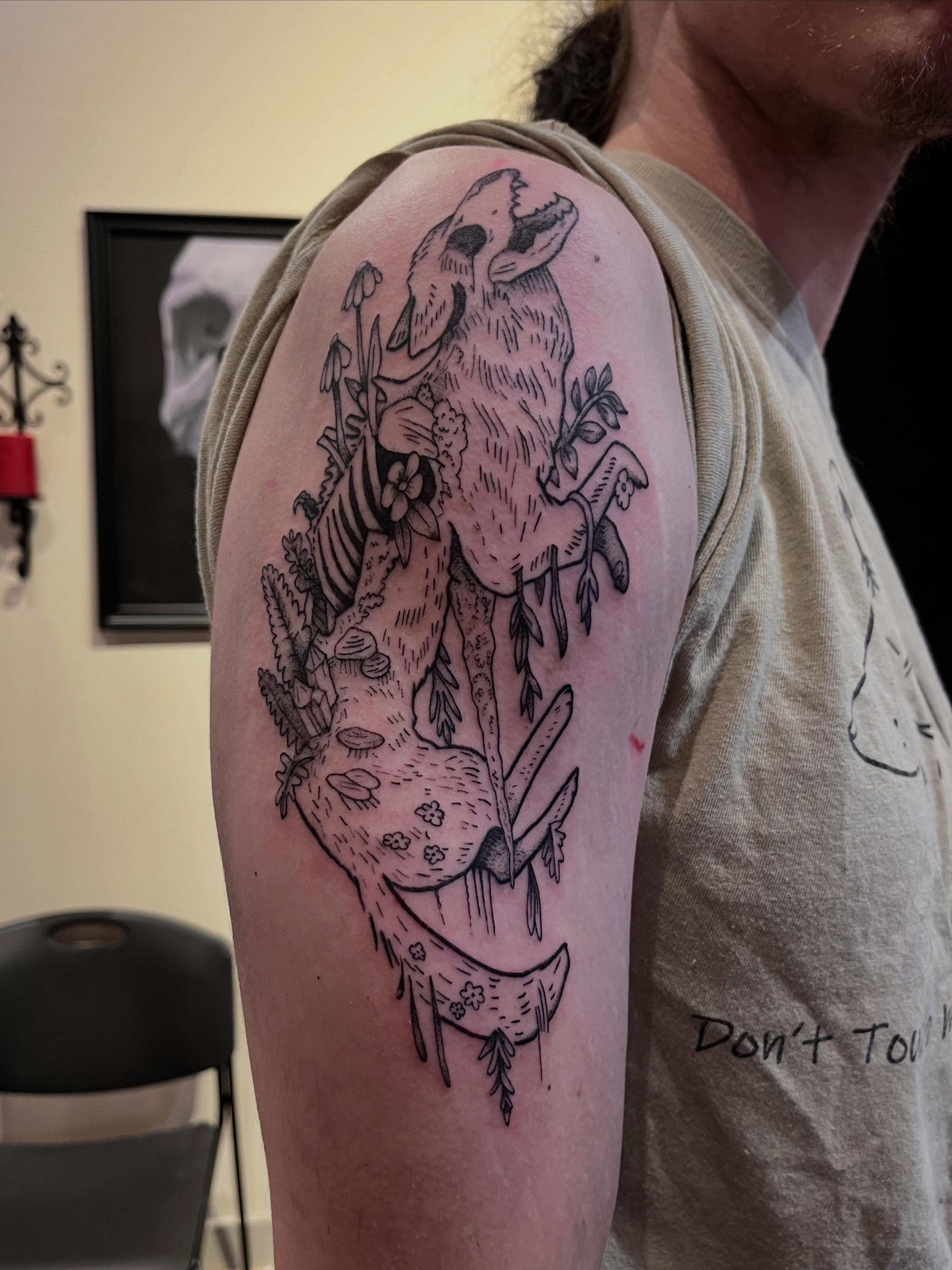 Deer and flowers black and grey tattoo on the upper arm by Tattoo Artist, Kansas City, Missouri