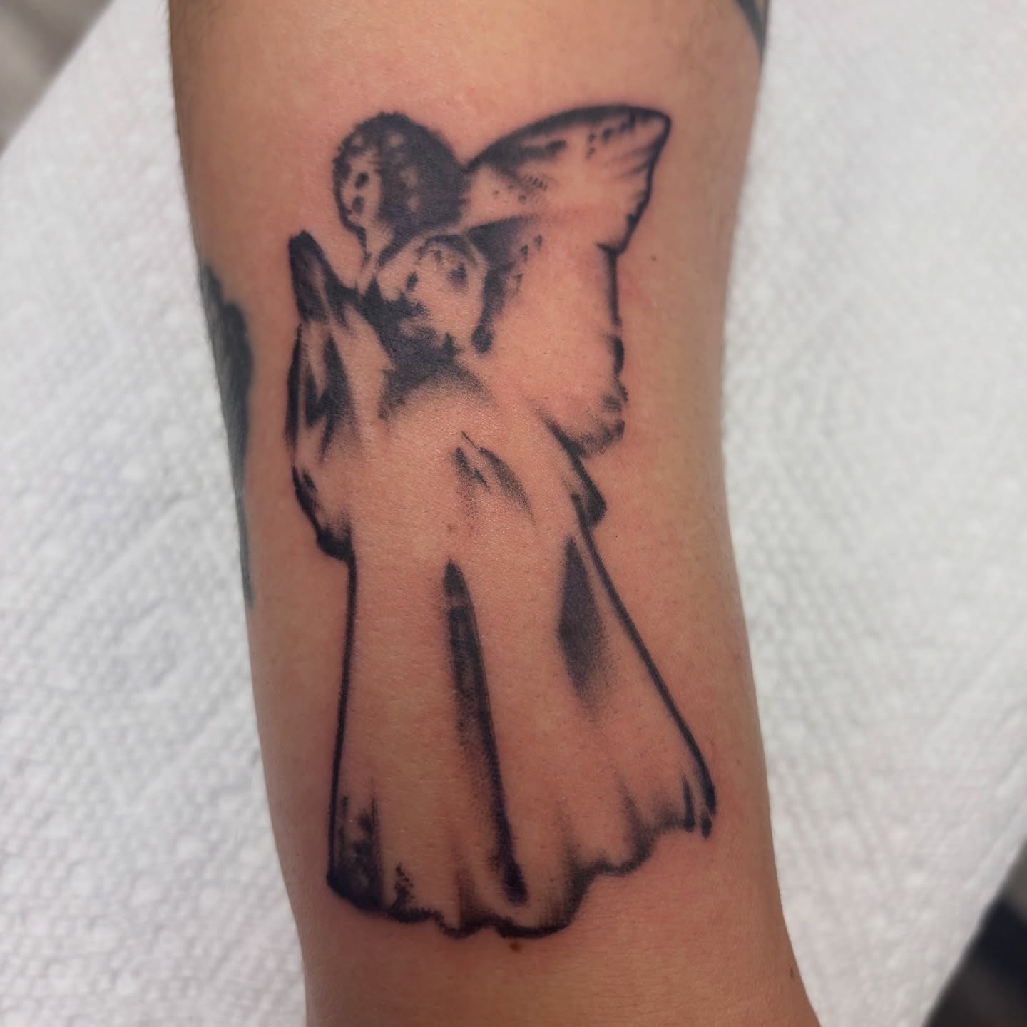 Statue black and grey tattoo on the forearm by Megan