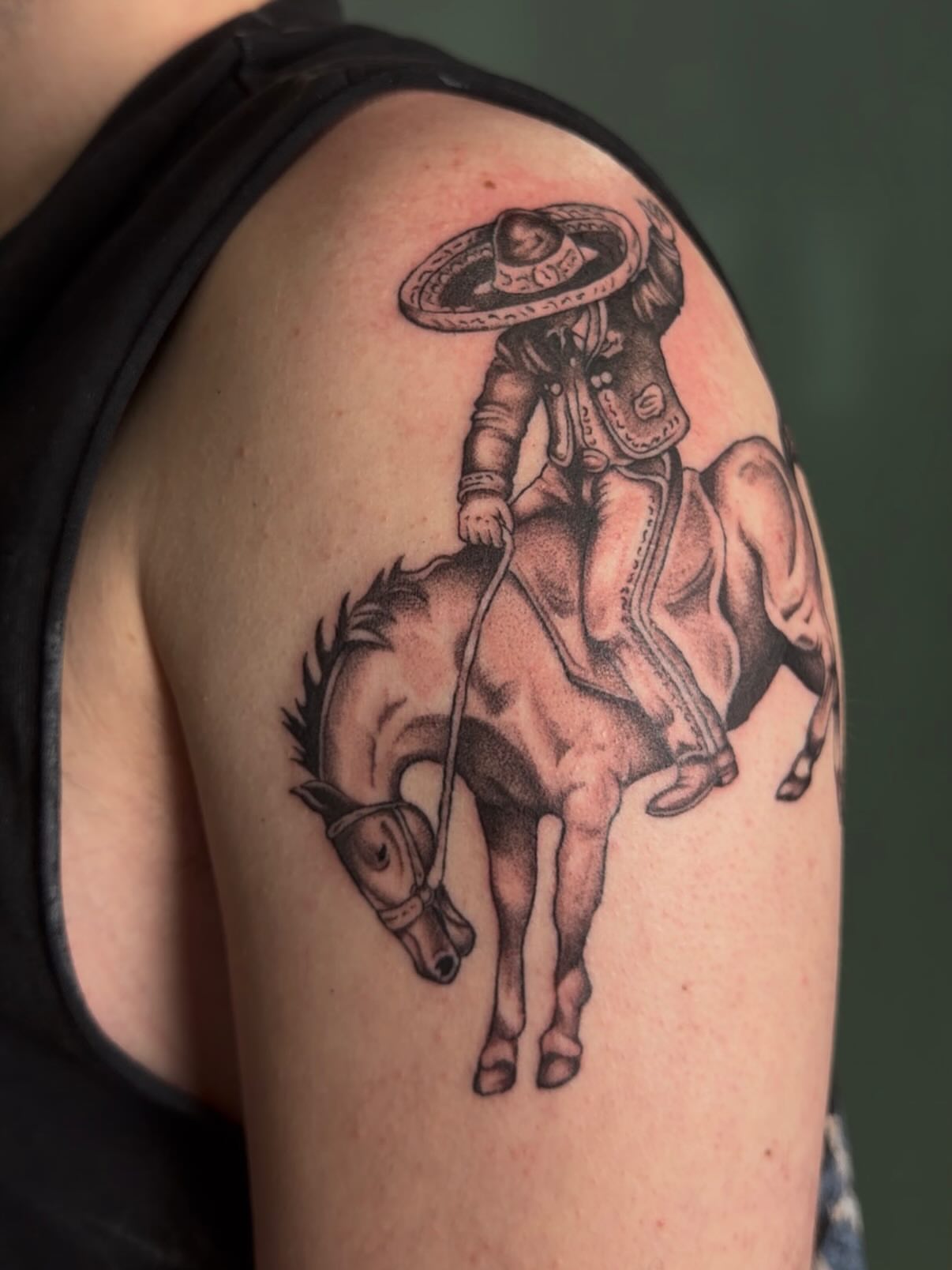 Cowboy on horse black and grey tattoo on the shoulder by Bailee