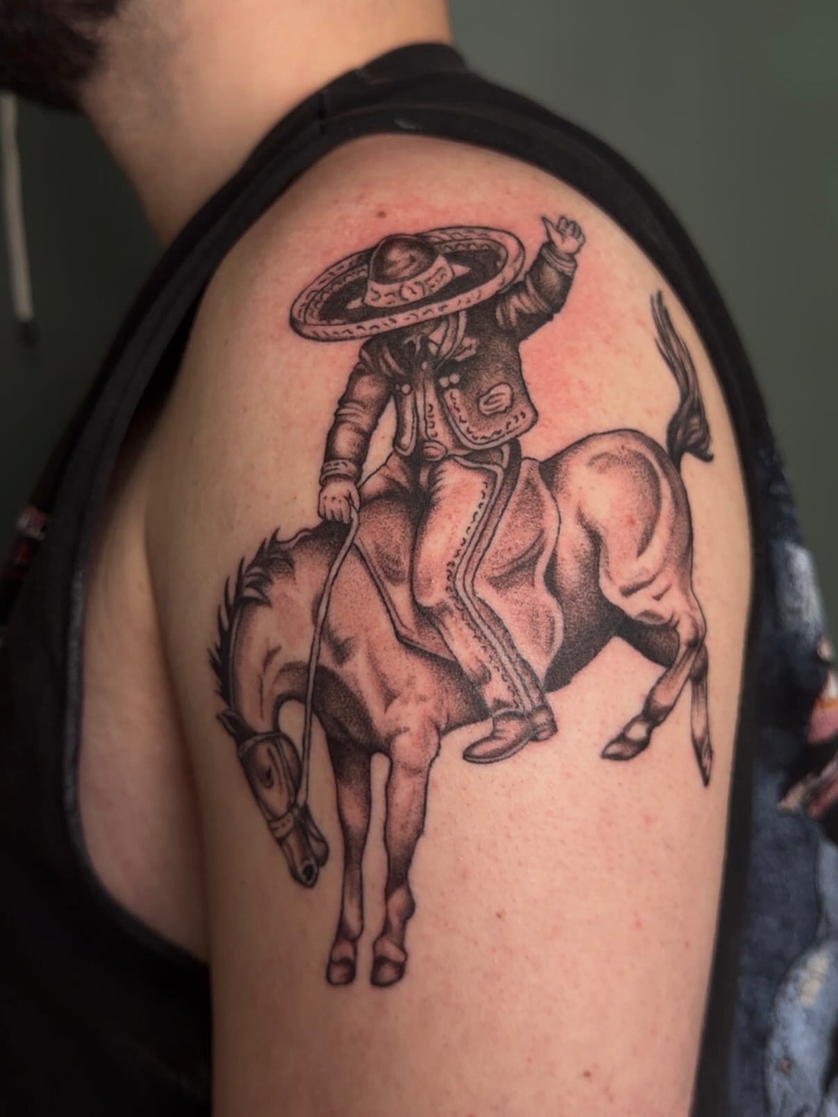 Rider on horse black and grey tattoo on the shoulder by Bailee