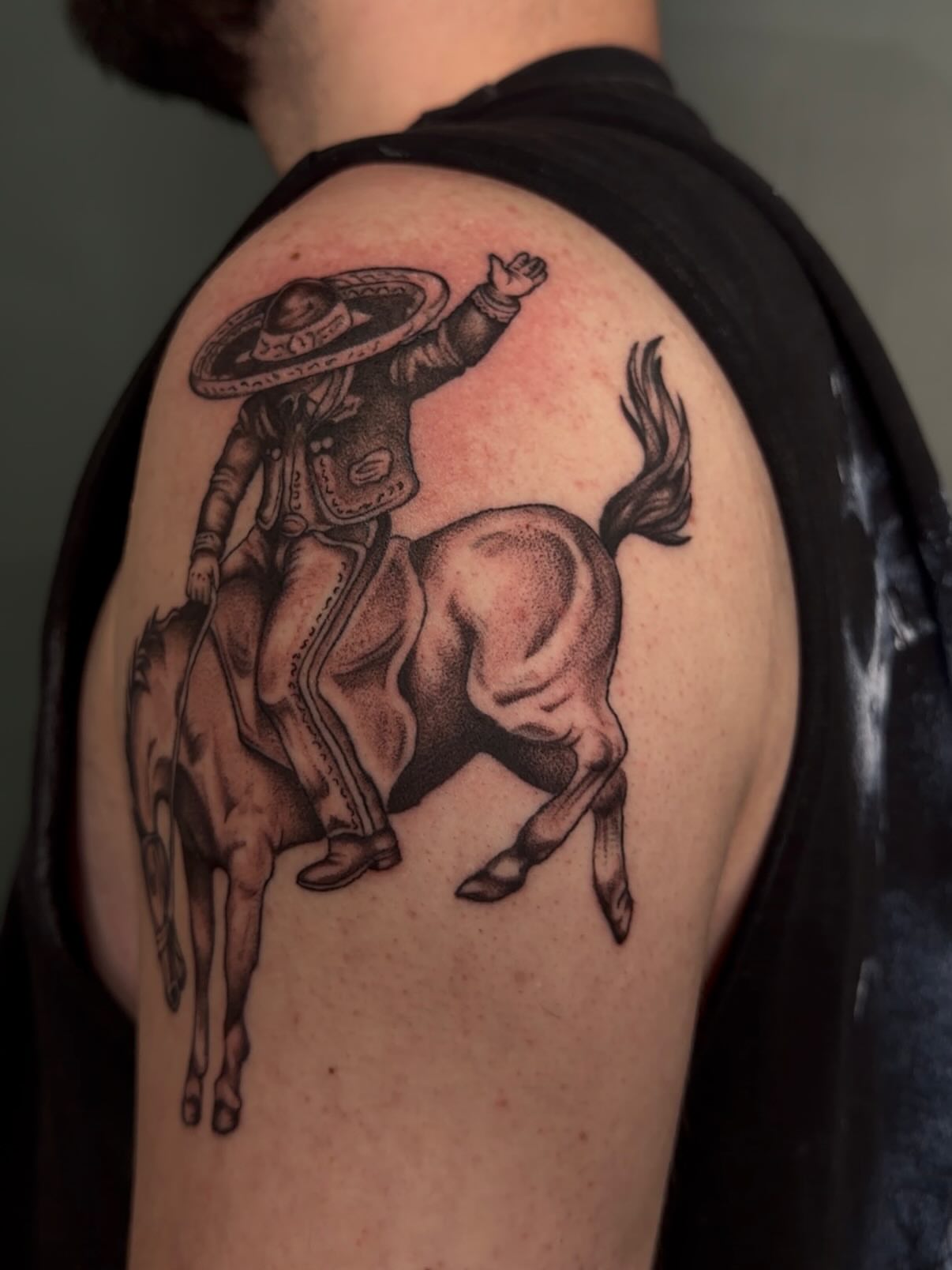 Rider on horse black and grey tattoo on the shoulder by Bailee